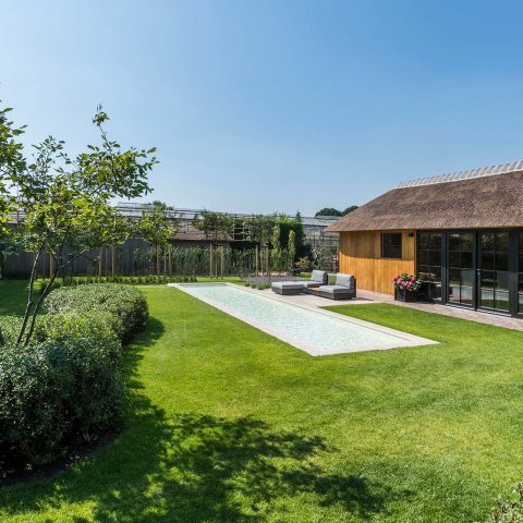 Rural garden with wooden outbuilding and swimming pool