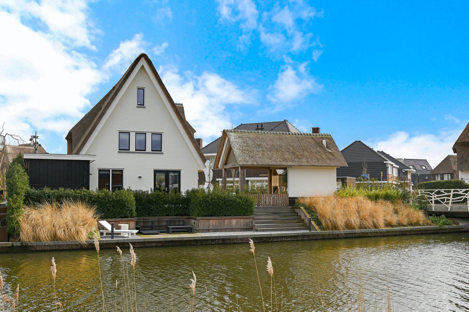 High end white villa with thatched roof, beautiful wooden deck, waterfront luxury ,Cottage,Housing,Building,House,Nature,Water,Outdoors,Grass,Neighborhood,Roof, Luxury, Design, Exclusive, Modern, Custom Made, Special, Beautiful