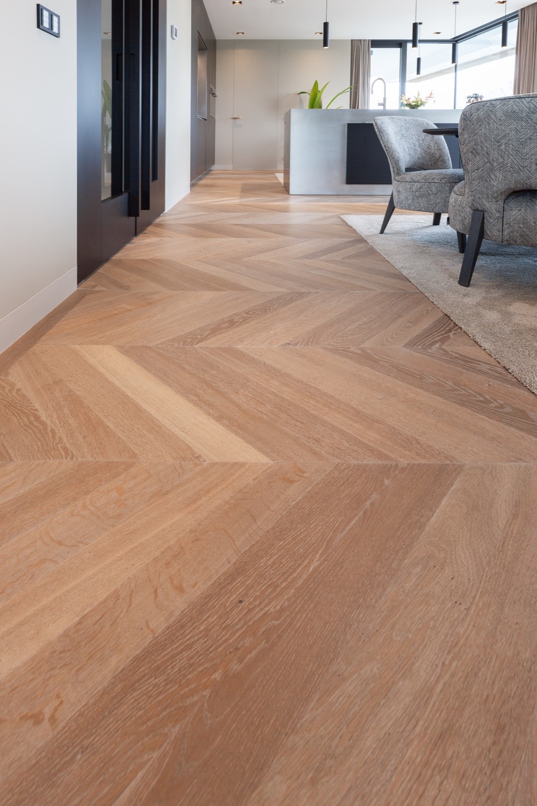 Hungarian point floor, long pile light grey rug, modern concrete kitchen island, fabric grey dining chairs ,Flooring,Floor,Rug,Wood,Furniture,Hardwood,Plywood,Interior Design,Indoors,Chair, Luxury, Design, Exclusive, Modern, Custom Made, Special, Beautiful