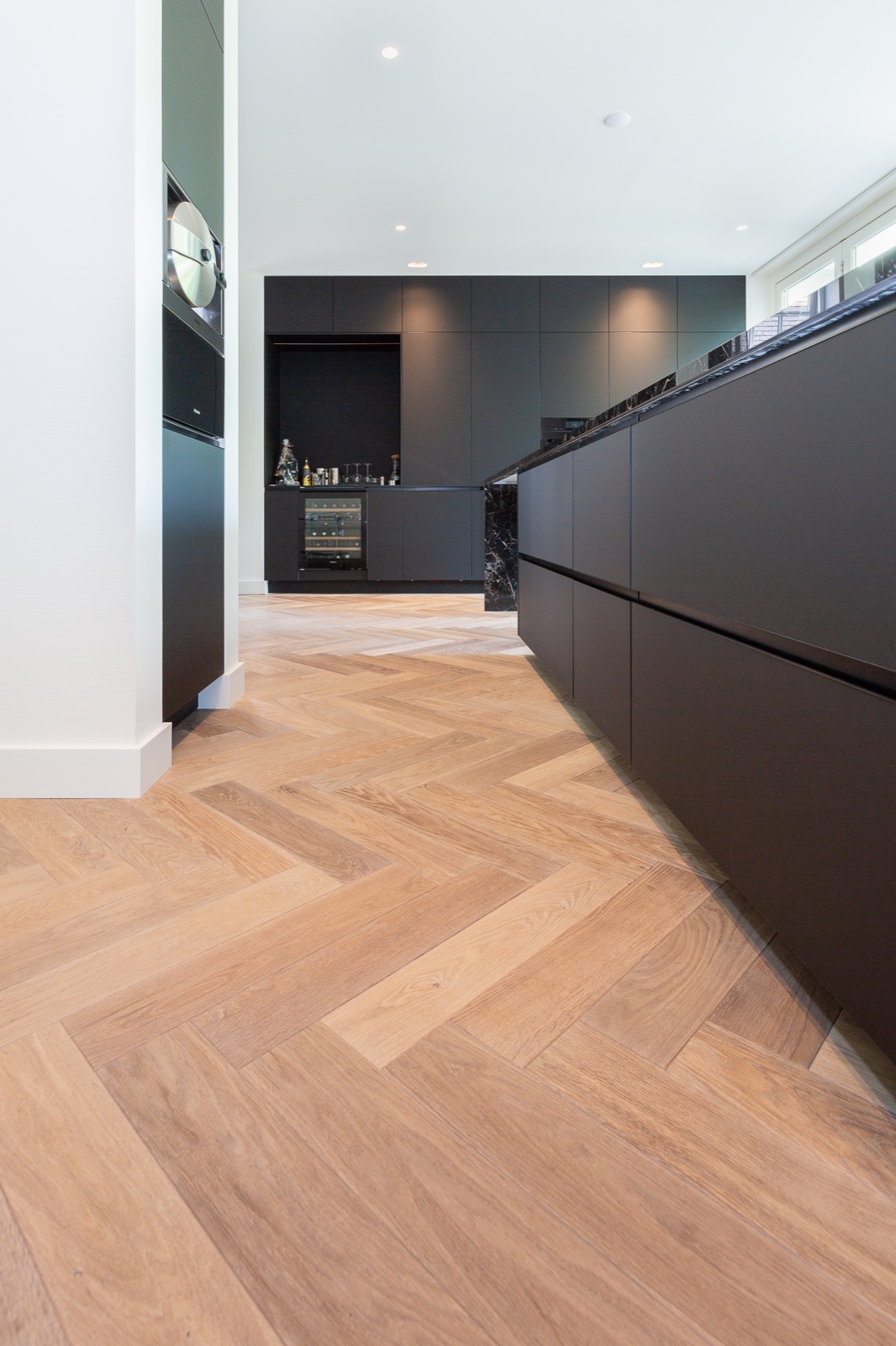 Modern wooden herringbone floor, luxurious black matt kitchen with cooking island ,Flooring,Floor,Interior Design,Indoors,Furniture,Wood,Rug,Hardwood,Room,Sideboard, Luxury, Design, Exclusive, Modern, Custom Made, Special, Beautiful