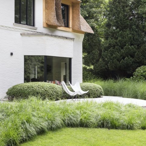Elegante tuin bij rietgedekte villa