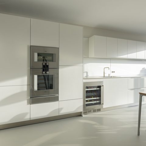 Long white bulthaup b3 kitchen with wine cabinet