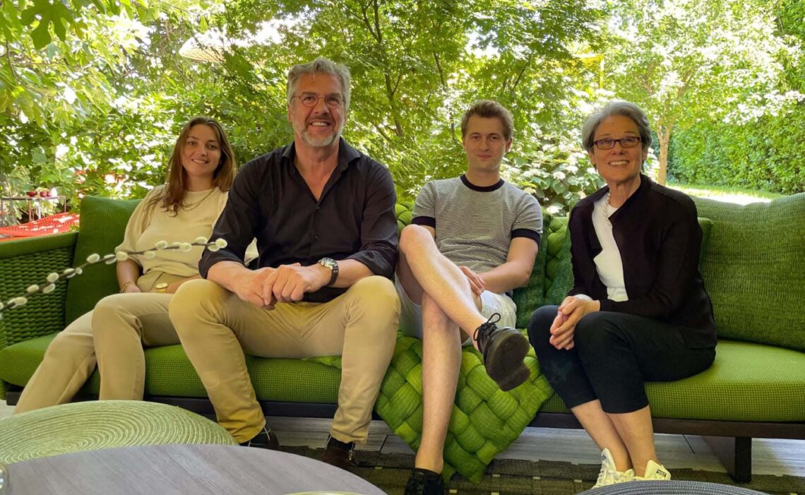 a group of people sitting on a bench posing for the camera