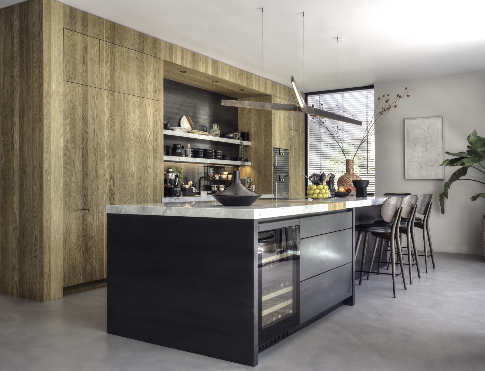 Gietvloer, donker houten barkrukken, luxe zilver metallic kookeiland met wit marmeren keukenblad, luxe houten keuken met metallic achterwand ,Interieurontwerp, Binnen, Keuken, Keukeneiland, Meubels, Houten panelen, Kast, Spoelkraan, Tafel, Eetkamer, Luxe, Design, Exclusief, Modern, Maatwerk, Bijzondere, Mooie