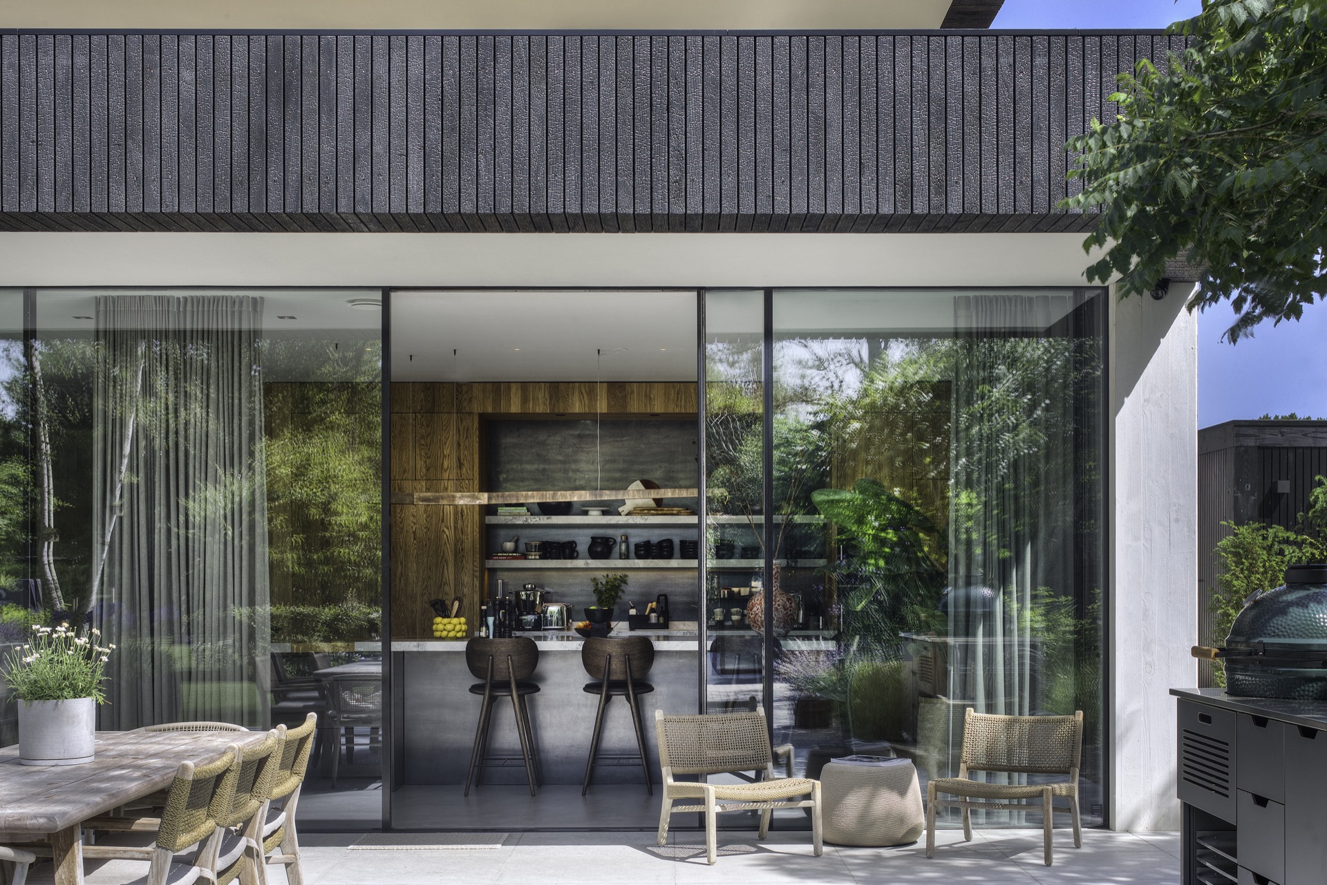 Design houten met witte villa, prachtige zwarte kozijnen, luxe open tuin, high end houten achterwand  ,Interieurontwerp, binnen, deur, schuifdeur, stoel, meubels, plant, behuizing, huis, eettafel, Luxe, Design, Exclusief, Modern, Maatwerk, Bijzondere, Mooie