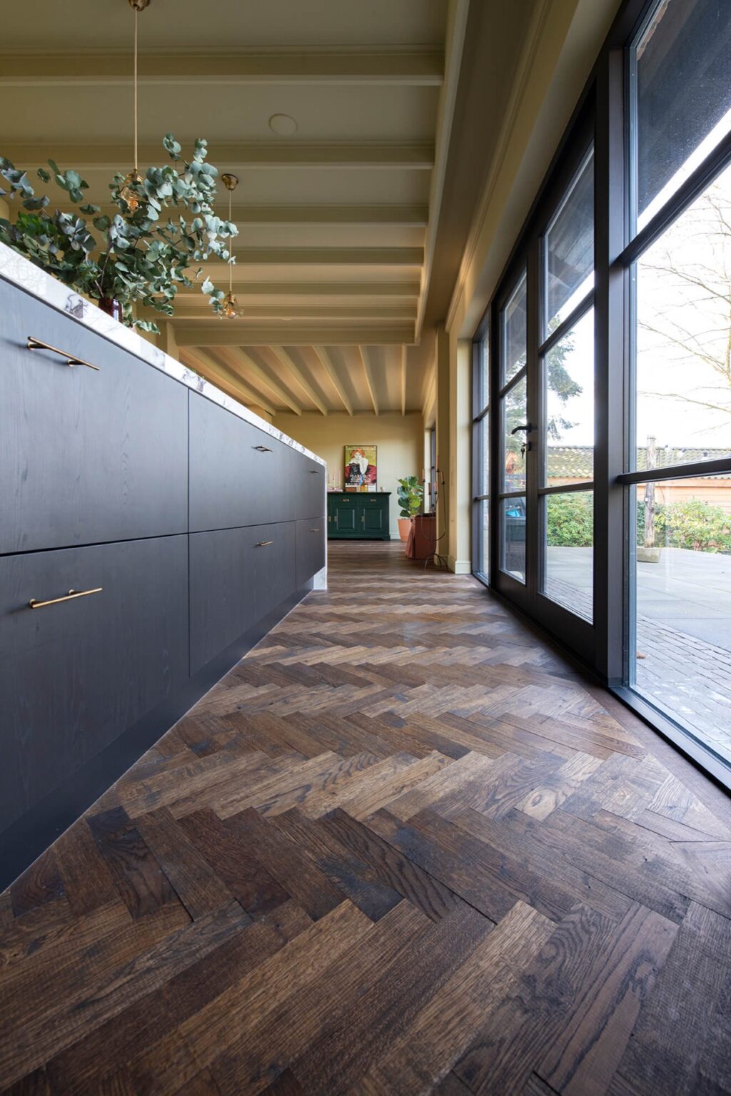 Dark herringbone floor with black kitchen with marble countertops