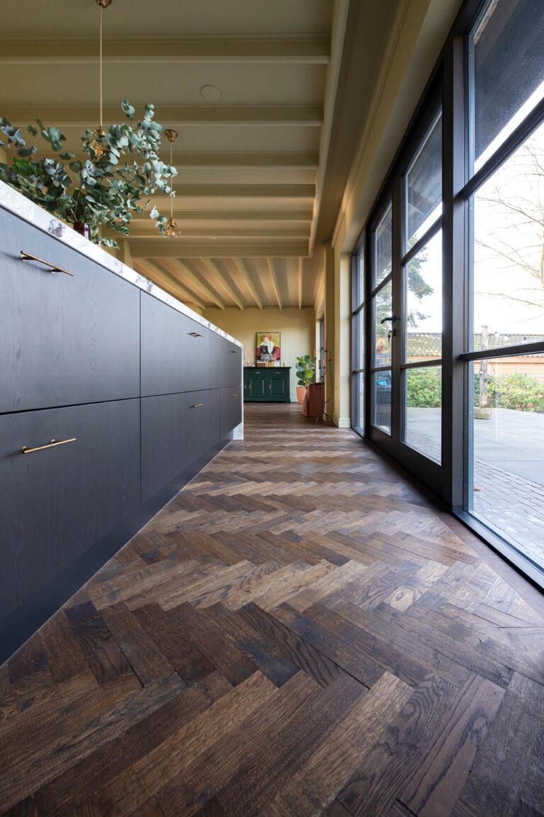 Dark herringbone floor with black kitchen with marble countertops