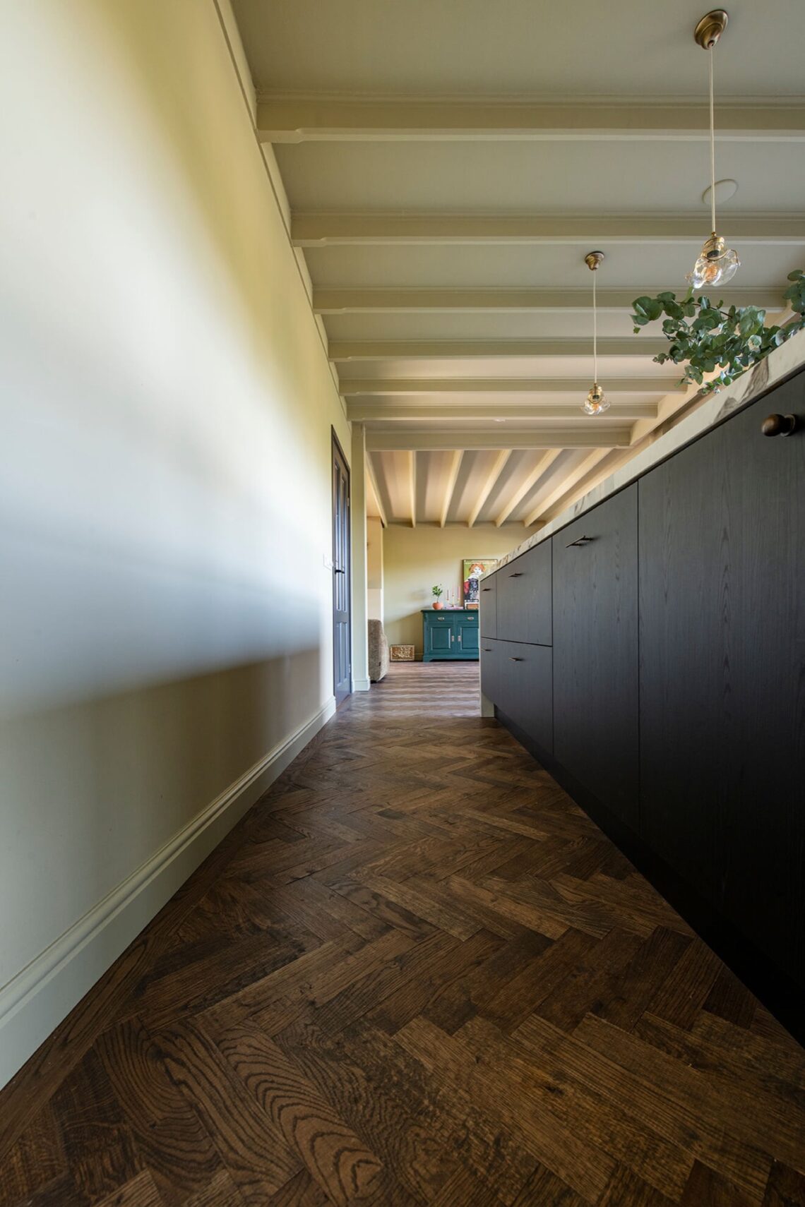Dark herringbone floor with black kitchen with marble countertops