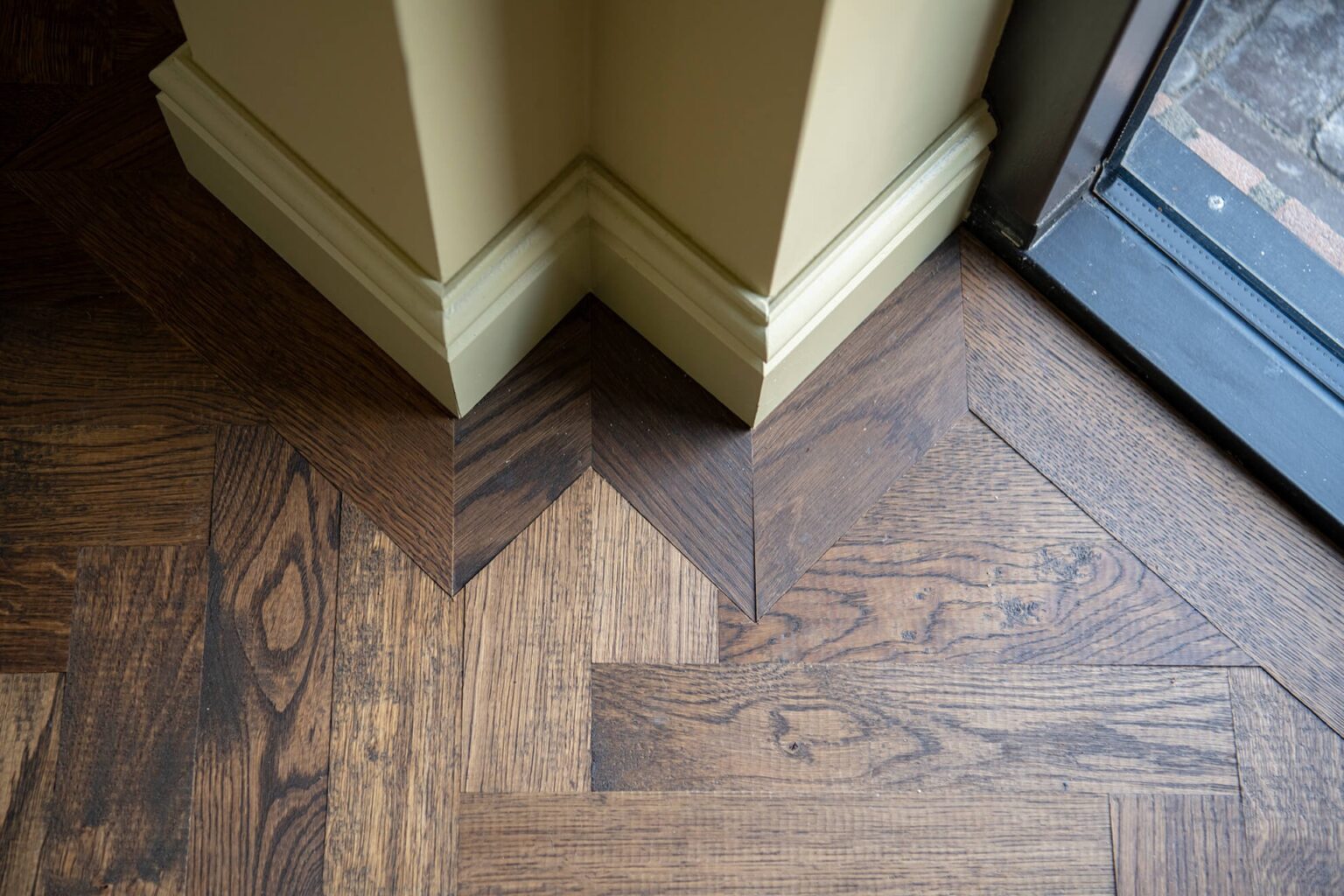 Dark herringbone floor with black kitchen with marble countertops
