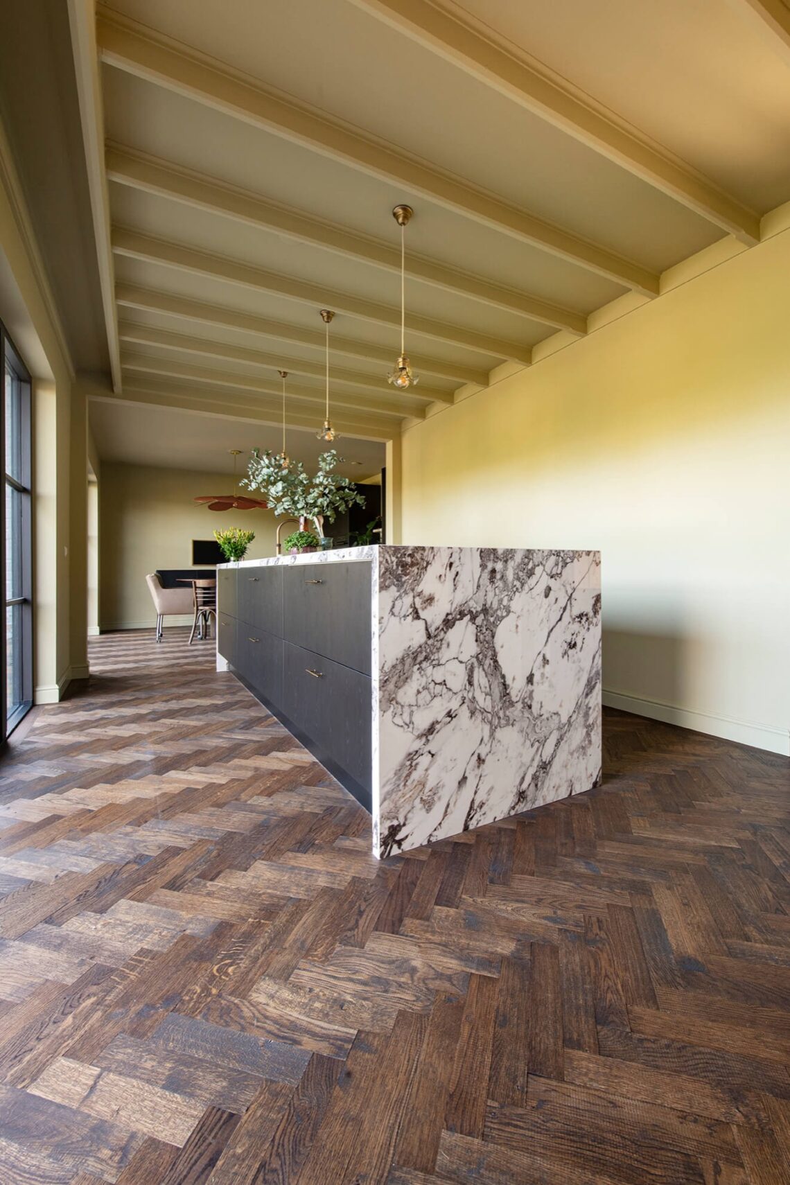 Dark herringbone floor with black kitchen with marble countertops