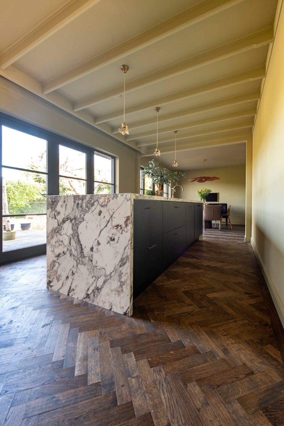 Dark herringbone floor with black kitchen with marble countertops