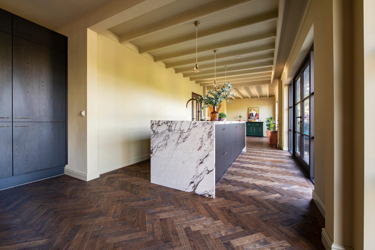 Dark herringbone floor with black kitchen with marble countertops