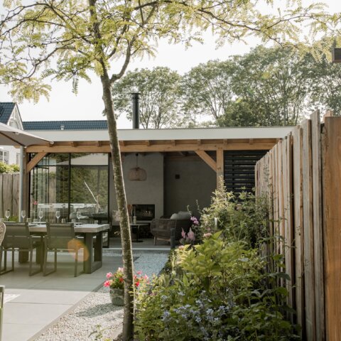 Moderne comfortabele buitenkeuken in sfeerrijke tuinkamer