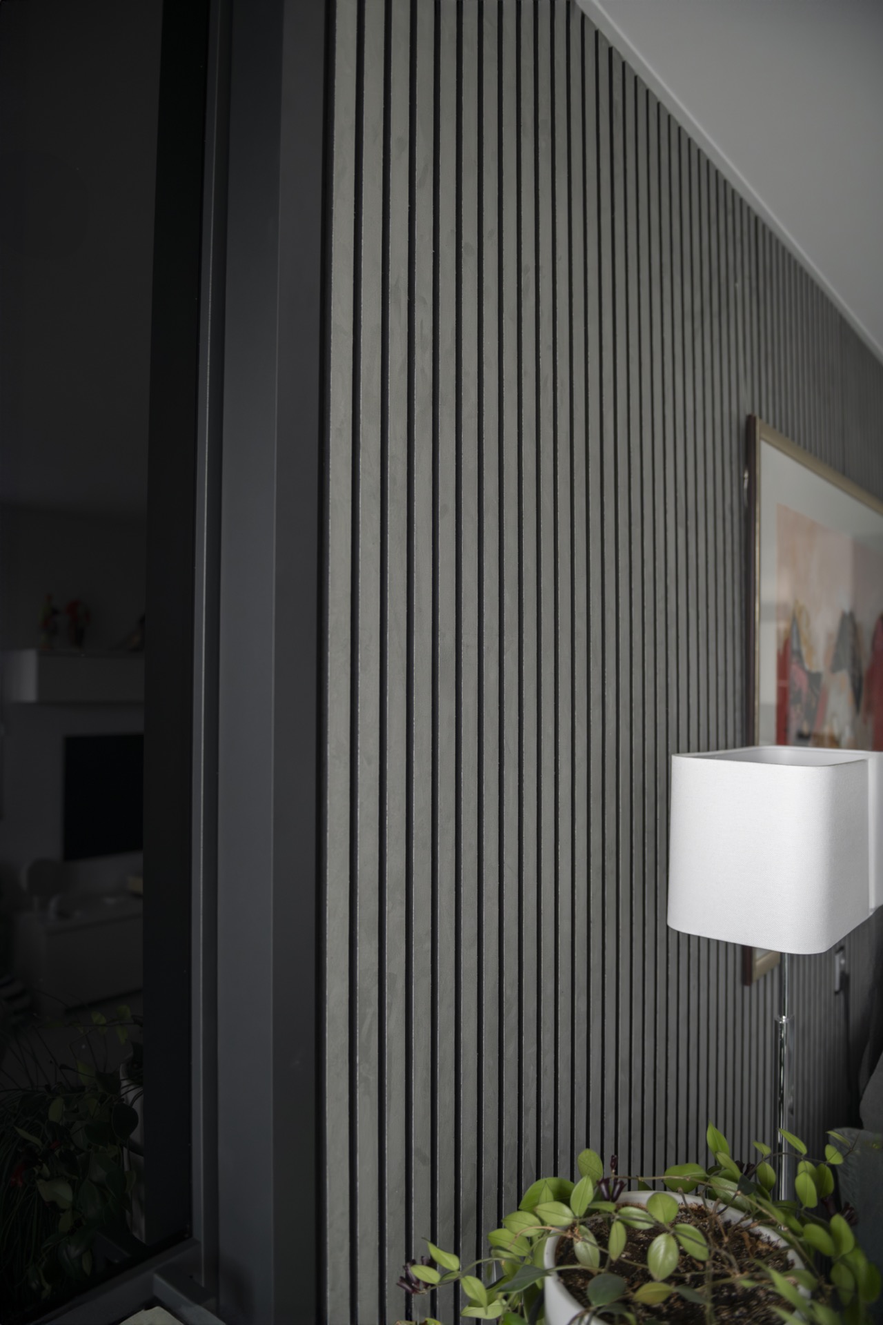 Akustikpaneele: Lampe an einer Wand mit schwarzen vertikalen Akustikpaneelen und grauer Suede-Filzoptik, Luxury, Design, Exclusive, Modern, Custom Made, Special, Beautiful