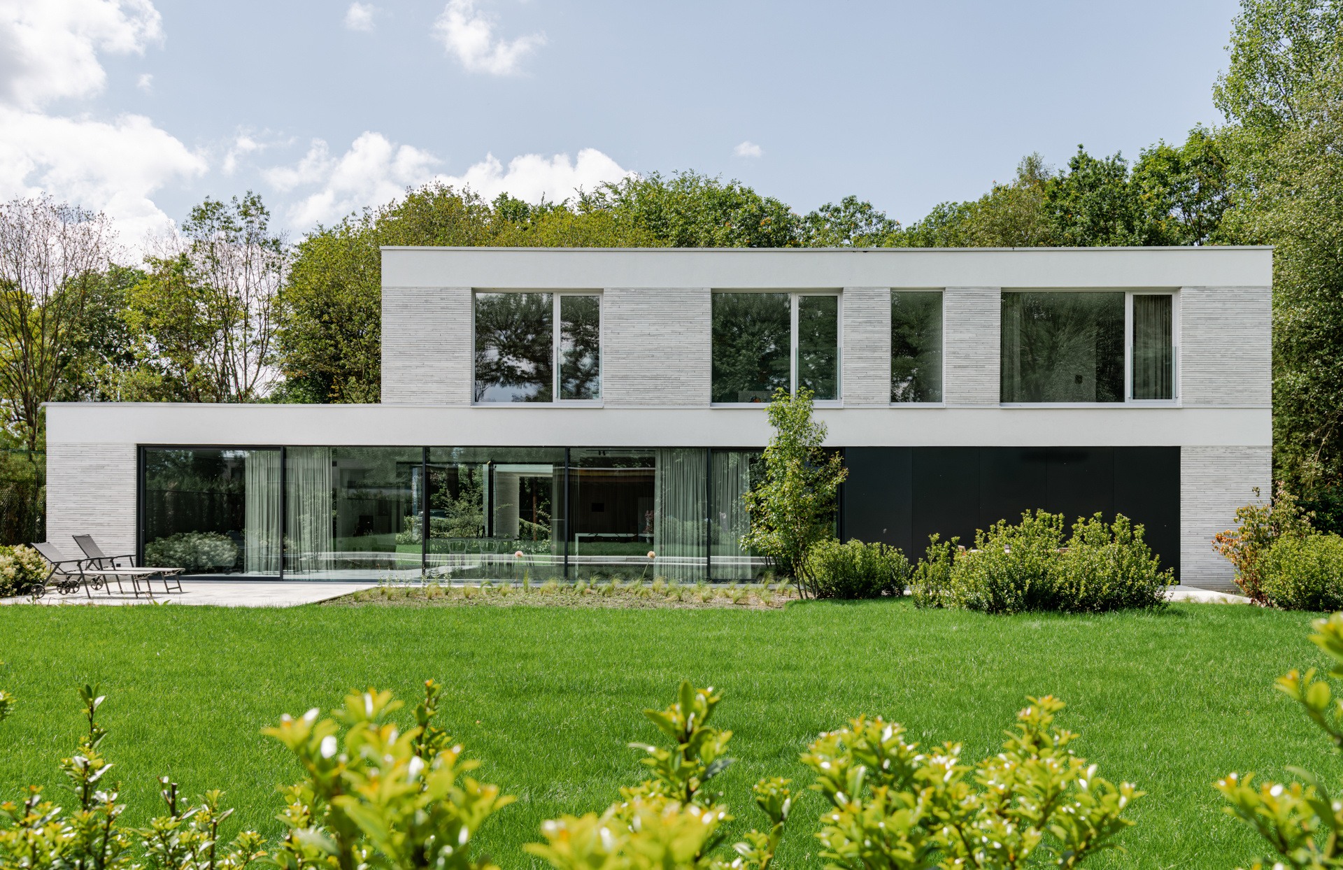 casa moderna industriale con spazio studio: lato terrazza con parete in vetro e tende a RESIDENCE G, Luxury, Design, Exclusive, Modern, Custom Made, Special, Beautiful