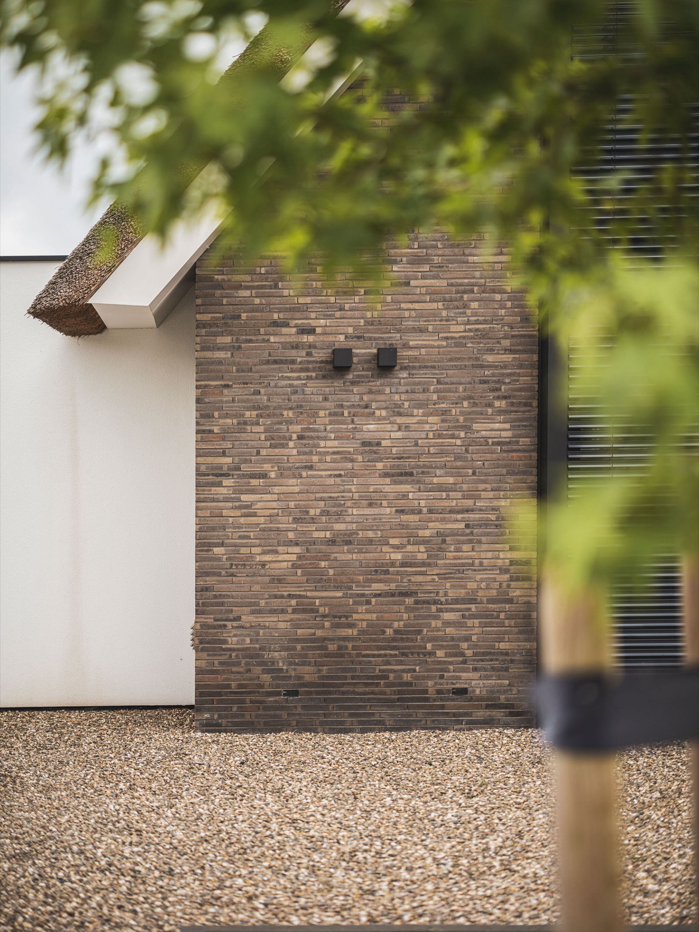 Villa mit Reetdach und Giebel: fassadendetail mit Ziegelstruktur, hellem Putzbereich und sichtbarer Reetdachkante, Luxury, Design, Exclusive, Modern, Custom Made, Special, Beautiful