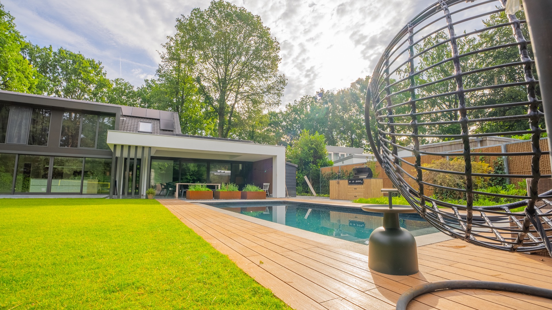 baukundiger Pool mit Betonterasse: schwimmbeckenrand mit Holzterrassendielen und Betonterasse an der Hausfassade, Luxury, Design, Exclusive, Modern, Custom Made, Special, Beautiful