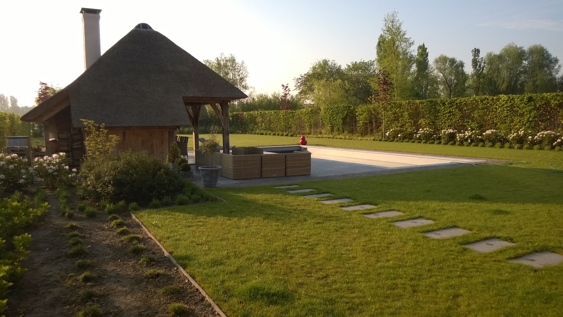 piscina en el jardín: césped con piedras de paso, borde de piscina y caseta de jardín de techo de paja en jardín campestre, Luxury, Design, Exclusive, Modern, Custom Made, Special, Beautiful