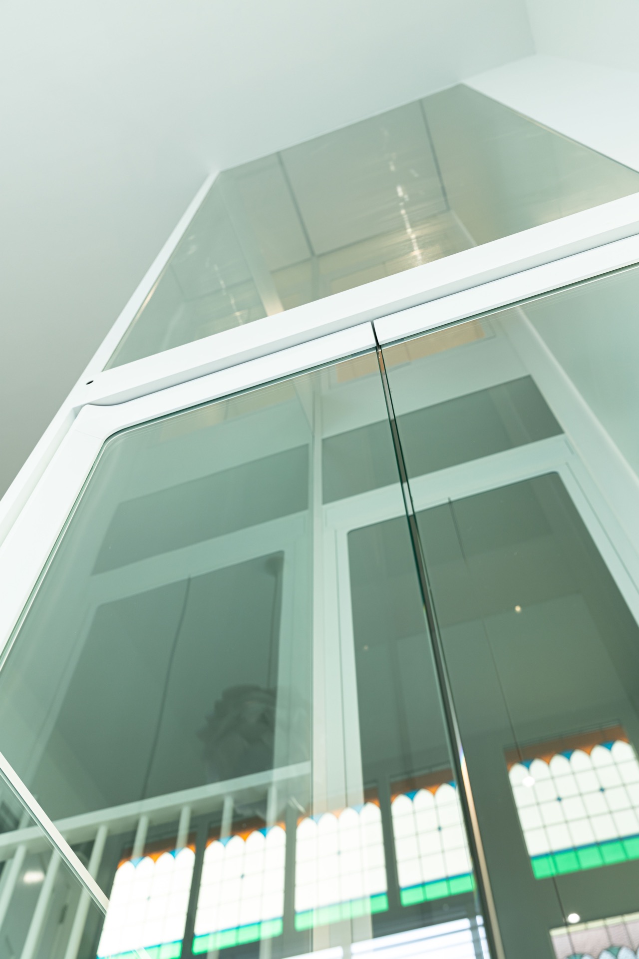 Glashomelift-Schacht: blick von unten in den Glas-Homelift mit weißen Profilen im oberen Bereich, Luxury, Design, Exclusive, Modern, Custom Made, Special, Beautiful