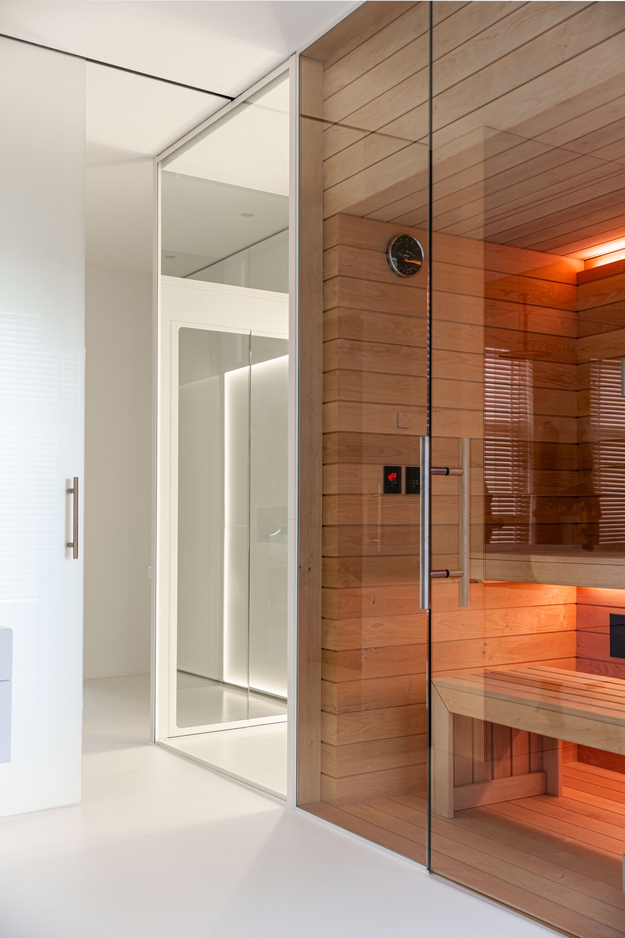 Glashomelift-Schacht: rechteckige Bedienungseinheit im Glas am Homelift mit Blick auf die Holzbsauna, Luxury, Design, Exclusive, Modern, Custom Made, Special, Beautiful