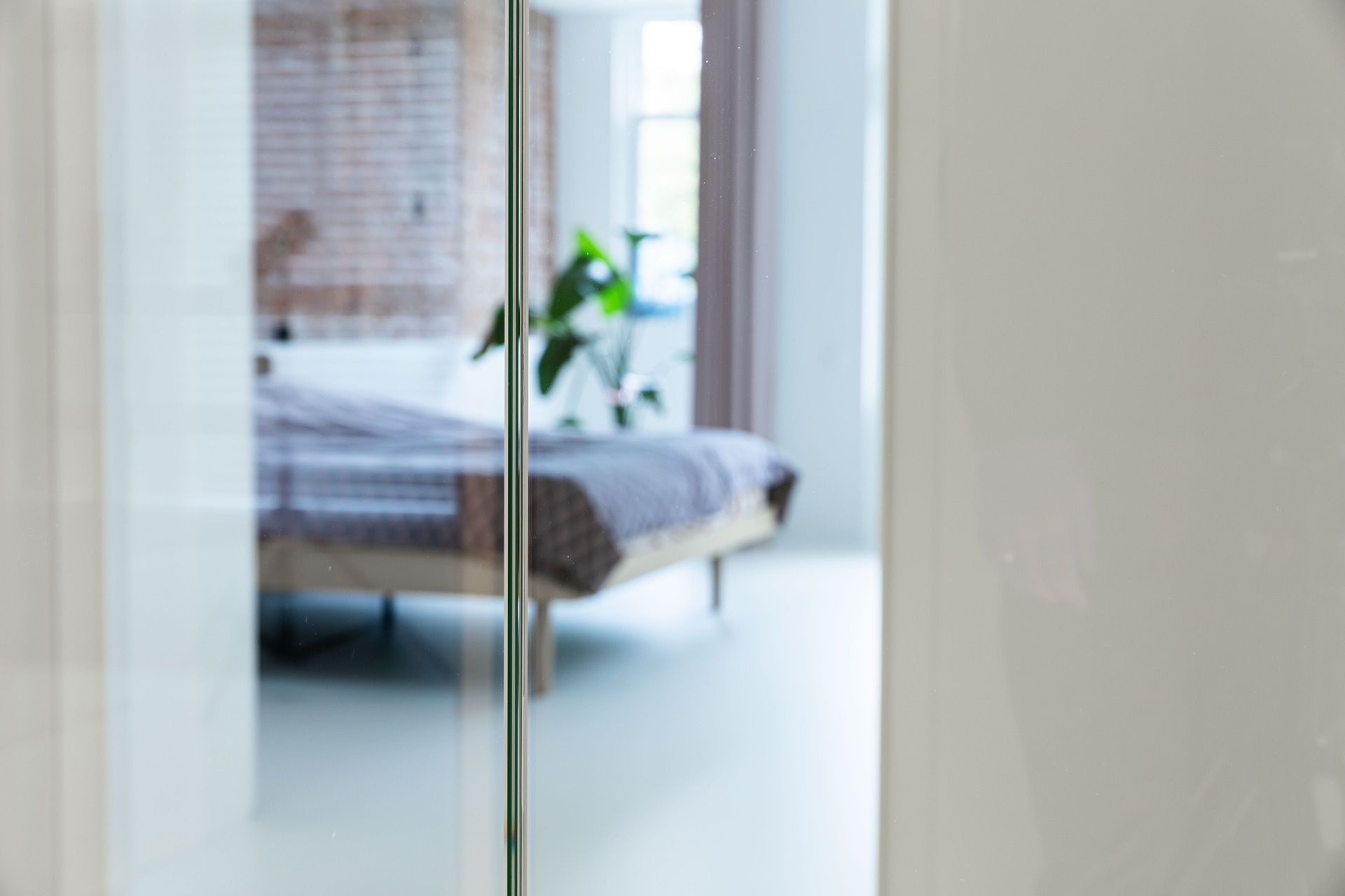Glashomelift-Schacht: nahaufnahme der Glaskante mit Metallprofil und weißem Rahmen rund um den Homelift-Zugang, Luxury, Design, Exclusive, Modern, Custom Made, Special, Beautiful