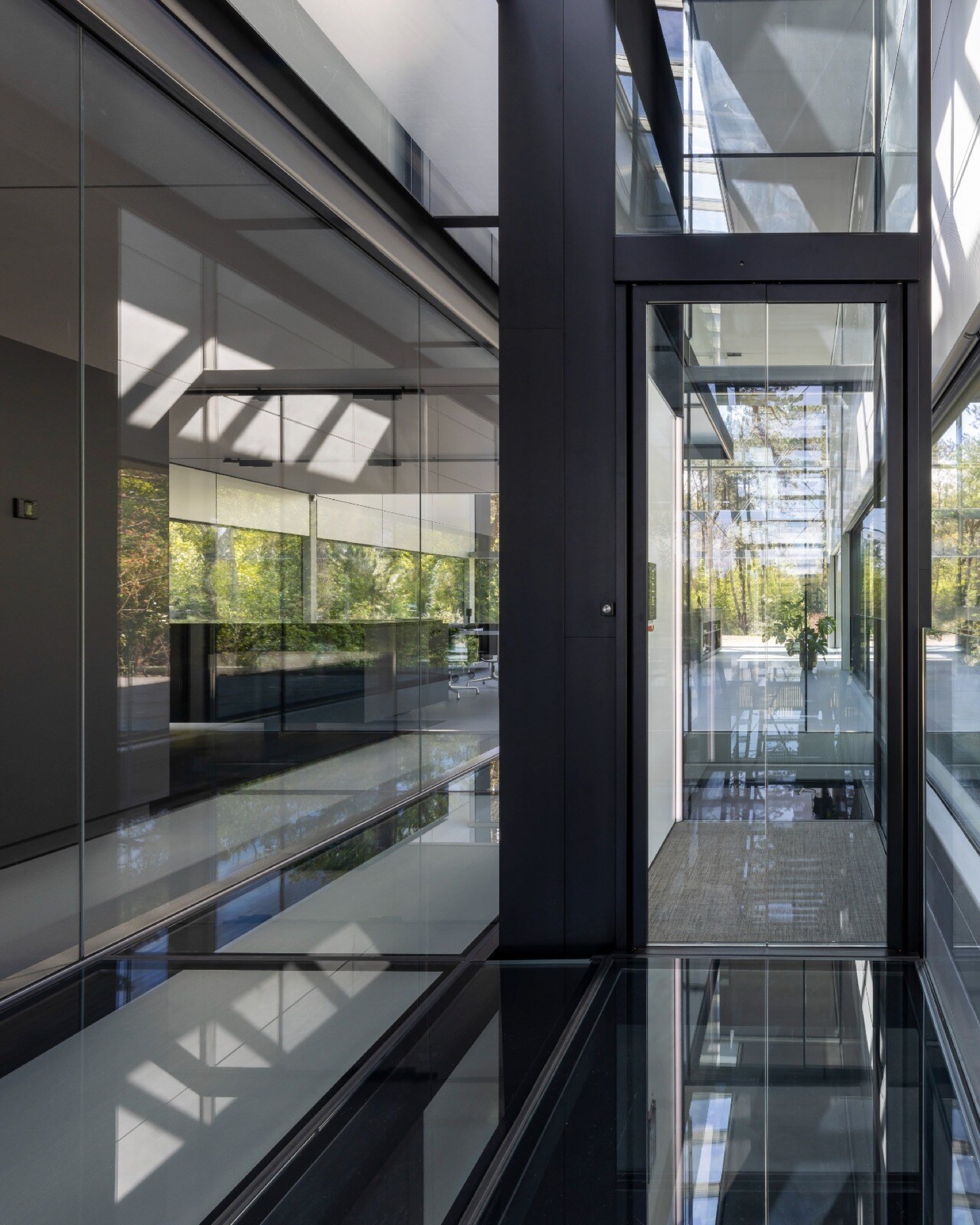 ascenseur privatif intégré dans une maison vitrée: vue intérieure avec cage d’ascenseur sombre, parois en verre et longue, Luxury, Design, Exclusive, Modern, Custom Made, Special, Beautiful