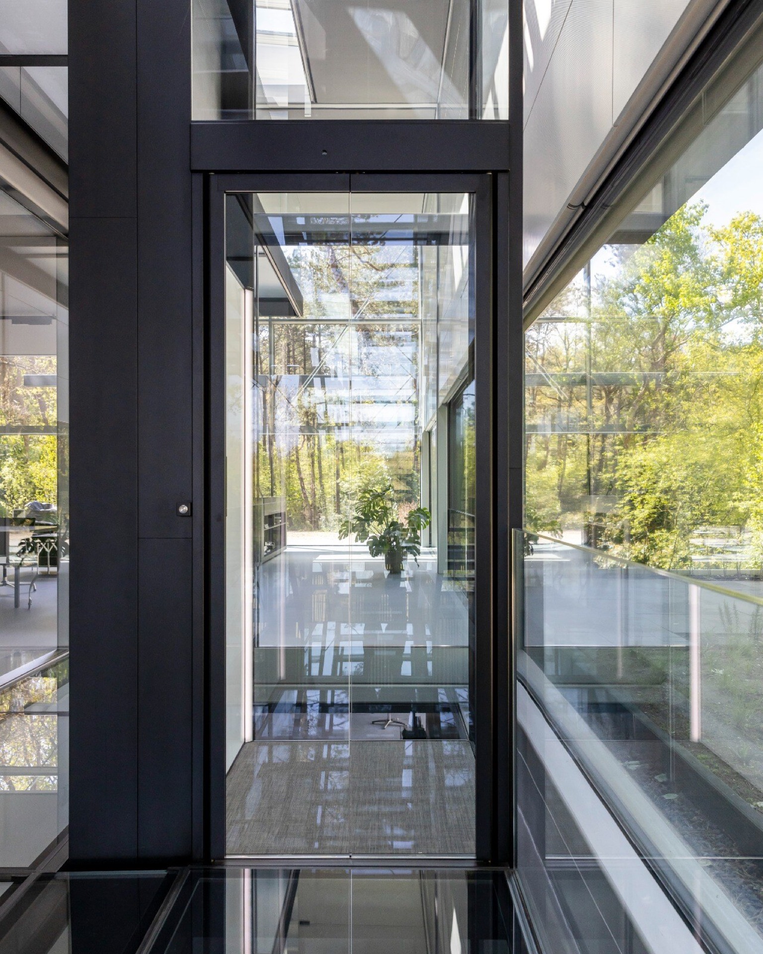 ascenseur privatif intégré dans une maison vitrée: intérieur avec ouverture de l’ascenseur et vue vers l’extérieur à travers, Luxury, Design, Exclusive, Modern, Custom Made, Special, Beautiful