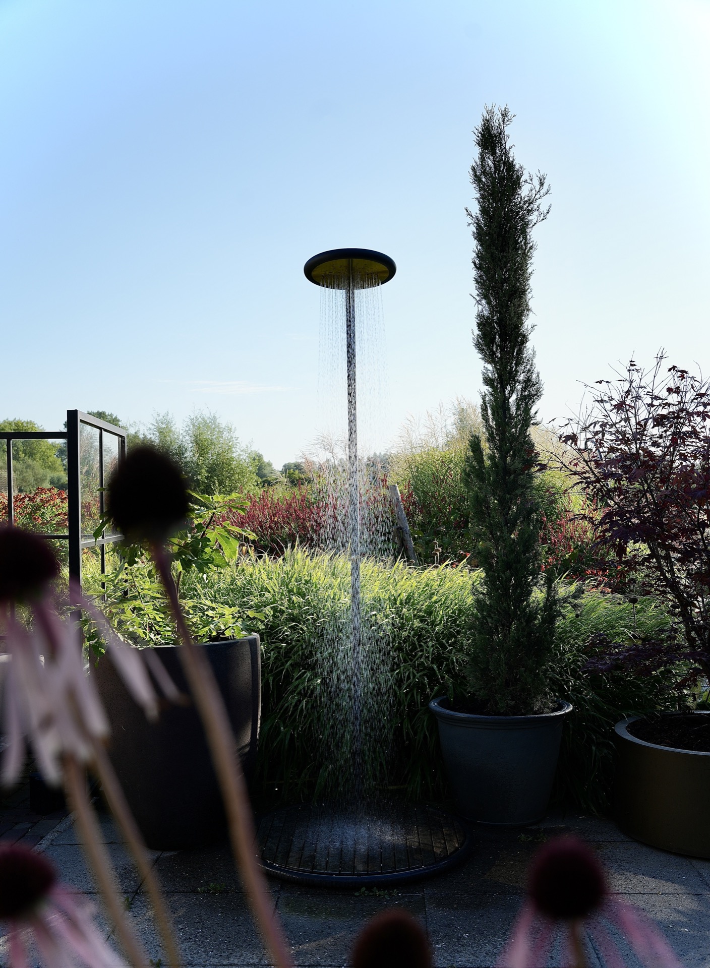 modern show garden with outdoor kitchen and lounge: lounge seating under a shade sail with flower borders in a modern show, Luxury, Design, Exclusive, Modern, Custom Made, Special, Beautiful
