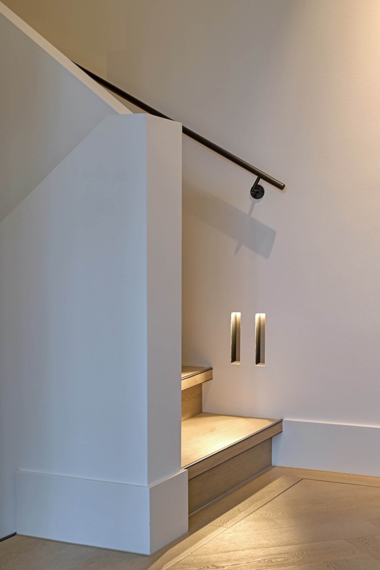 indirect LED lighting in a luxury villa interior: stair opening with track lighting on a black rail and warm ambient glow, Luxury, Design, Exclusive, Modern, Custom Made, Special, Beautiful