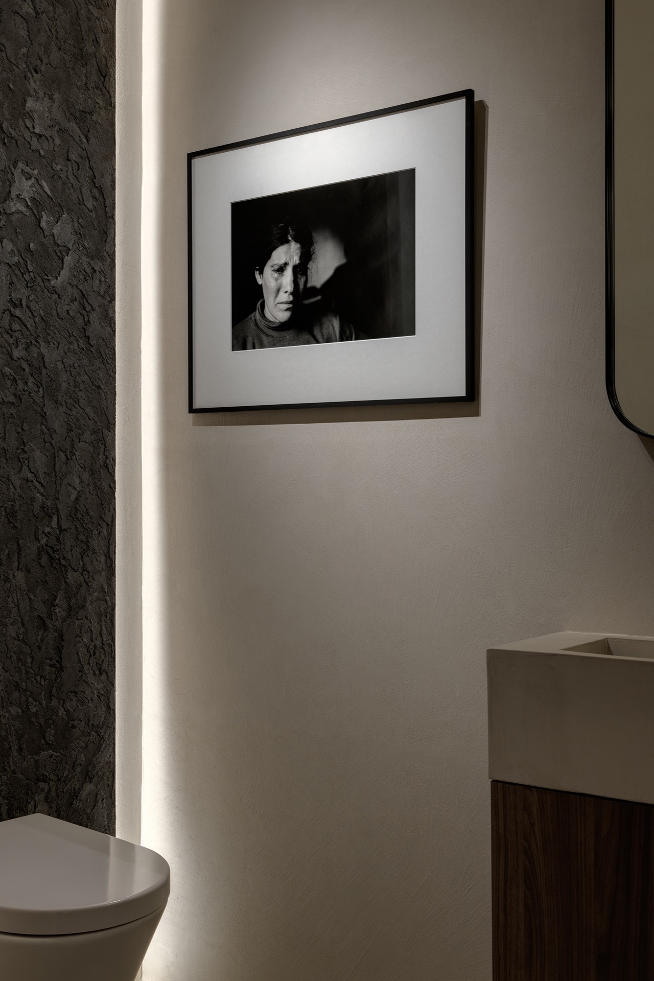 interior lighting plan: detail of a textured stone wall with framed artwork and soft indirect light, Luxury, Design, Exclusive, Modern, Custom Made, Special, Beautiful