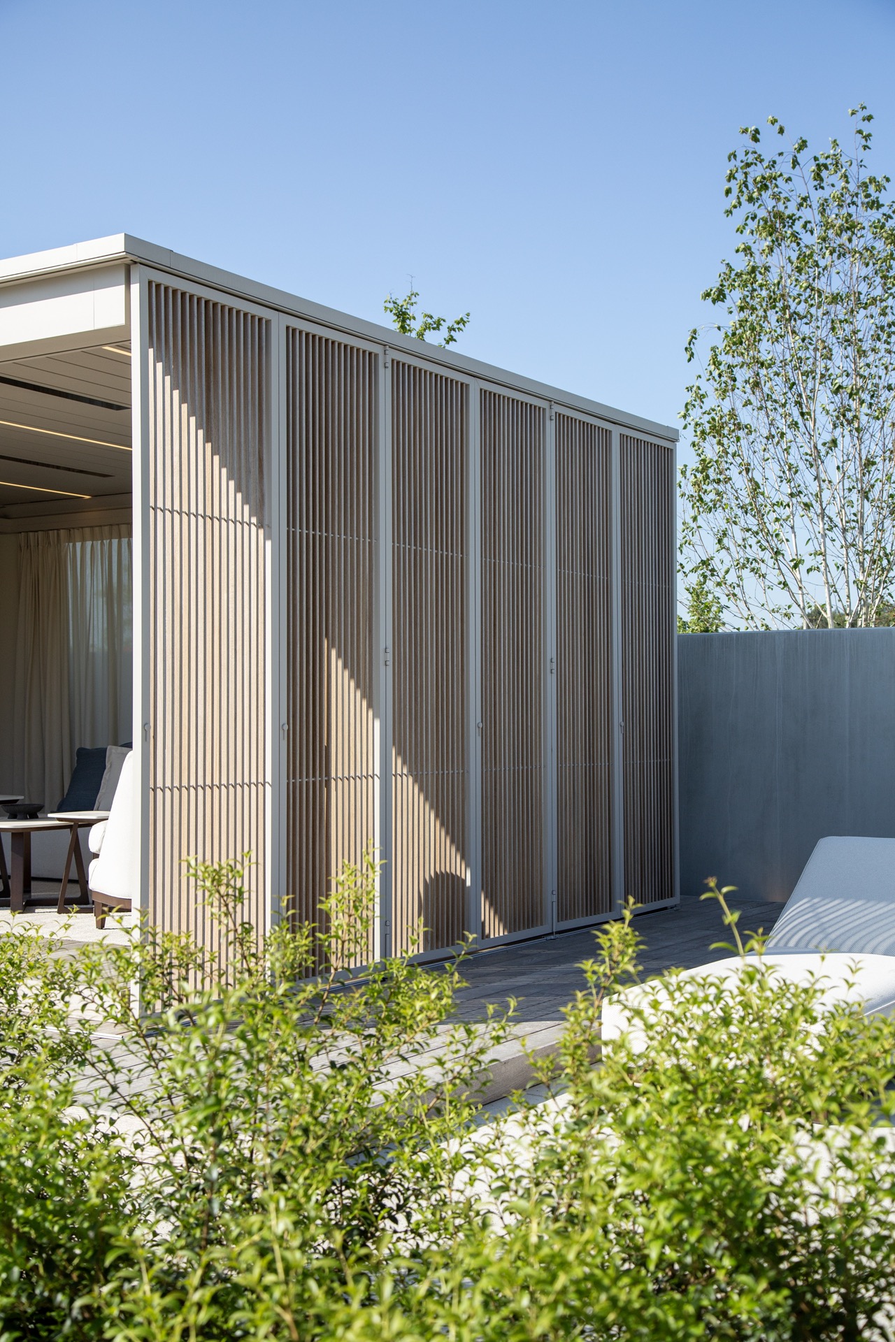 modernes Gartenhaus mit überdachter Terrasse: seitenfassade eines modernen Gartenraums mit vertikalen Lamellen und Glasfront, Luxury, Design, Exclusive, Modern, Custom Made, Special, Beautiful