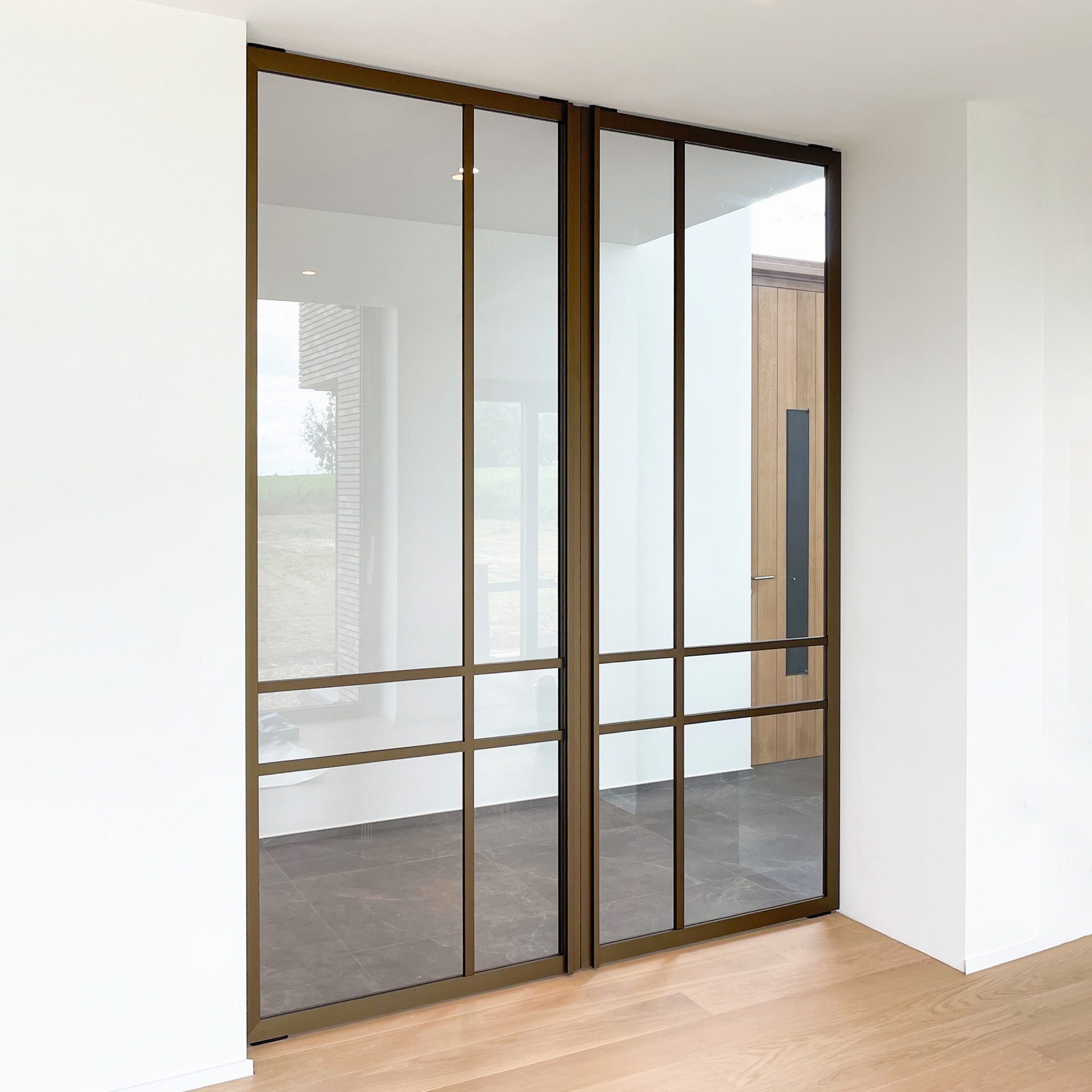 porta pivot effetto acciaio in vetro: porta pivot taats con vetro e cornice scura con vista su un’area porta in legno, Luxury, Design, Exclusive, Modern, Custom Made, Special, Beautiful