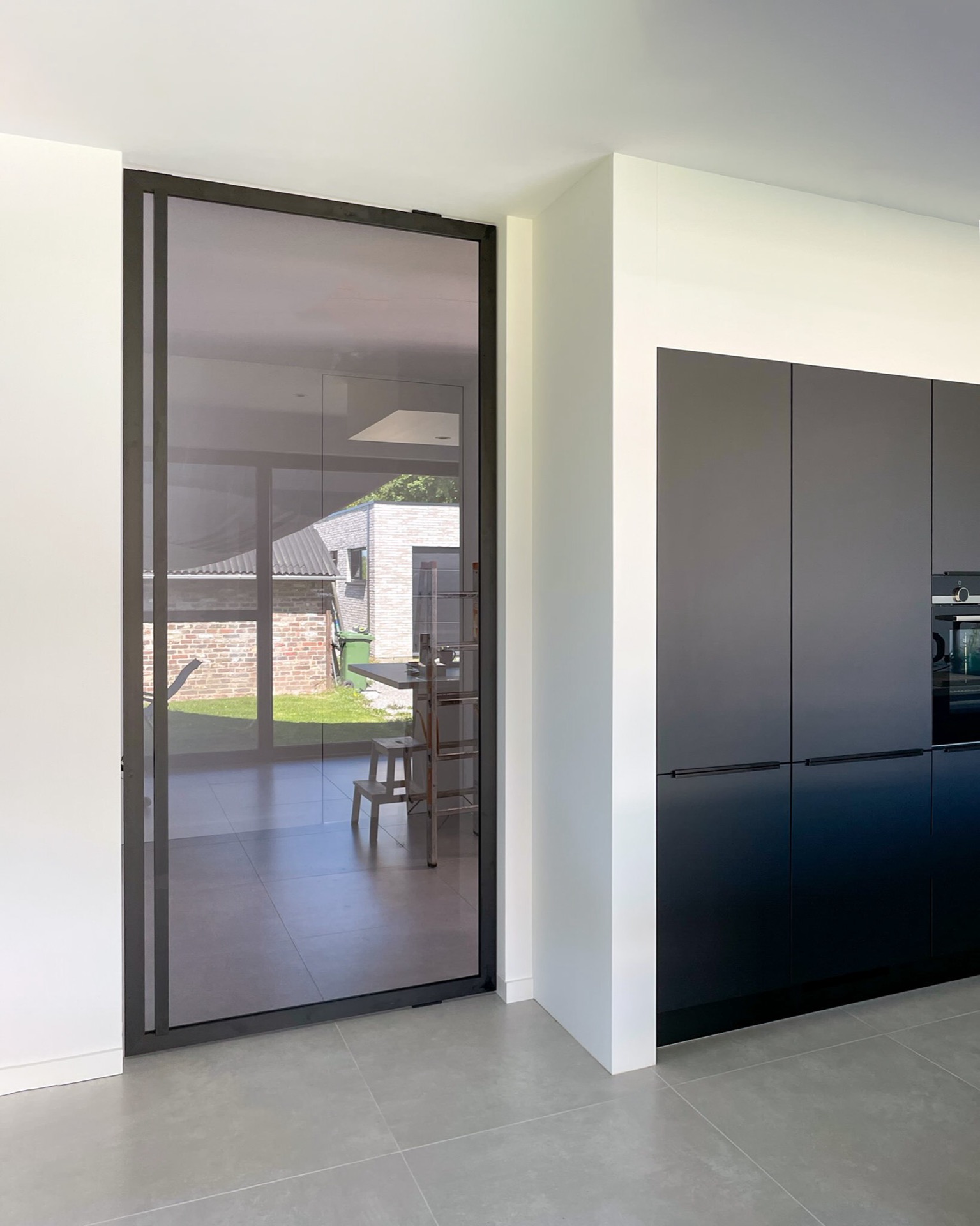 porta pivot effetto acciaio in vetro: porta pivot taats con vetro e cornice scura in un pianerottolo con vista sulla scala, Luxury, Design, Exclusive, Modern, Custom Made, Special, Beautiful
