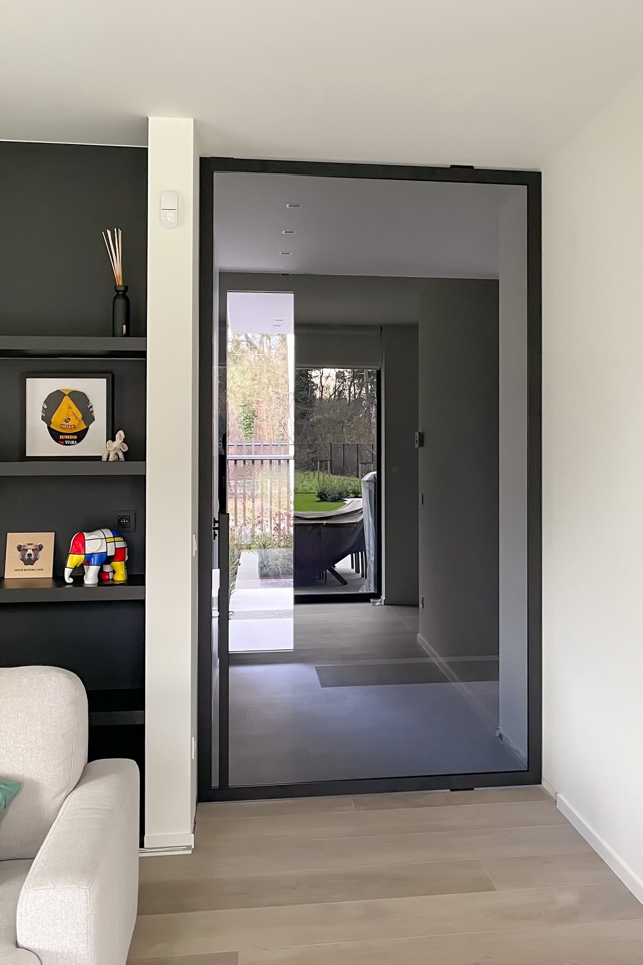porta pivot effetto acciaio in vetro: porta taats effetto acciaio con vetro e cornice scura in un soggiorno moderno con, Luxury, Design, Exclusive, Modern, Custom Made, Special, Beautiful
