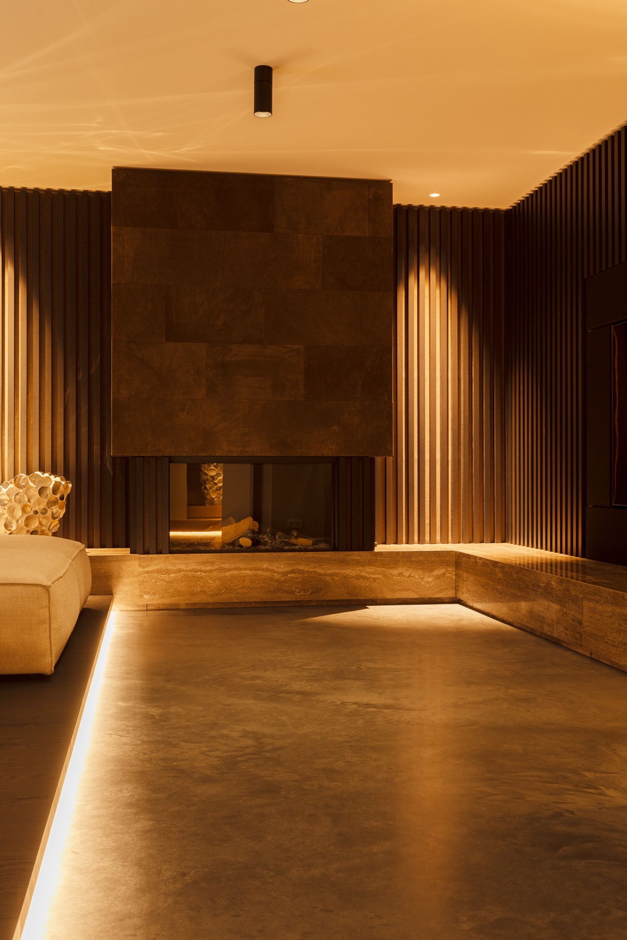floated concrete floor in new-build villa: living room with floated concrete floor, wood slat wall and warm recessed lighting, Luxury, Design, Exclusive, Modern, Custom Made, Special, Beautiful