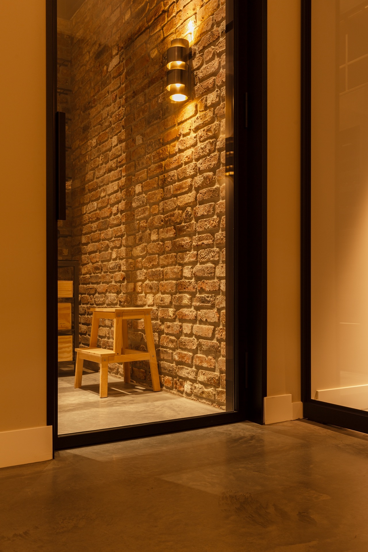 floated concrete floor in new-build villa: close-up of brick wall with wall lights and warm illumination, Luxury, Design, Exclusive, Modern, Custom Made, Special, Beautiful