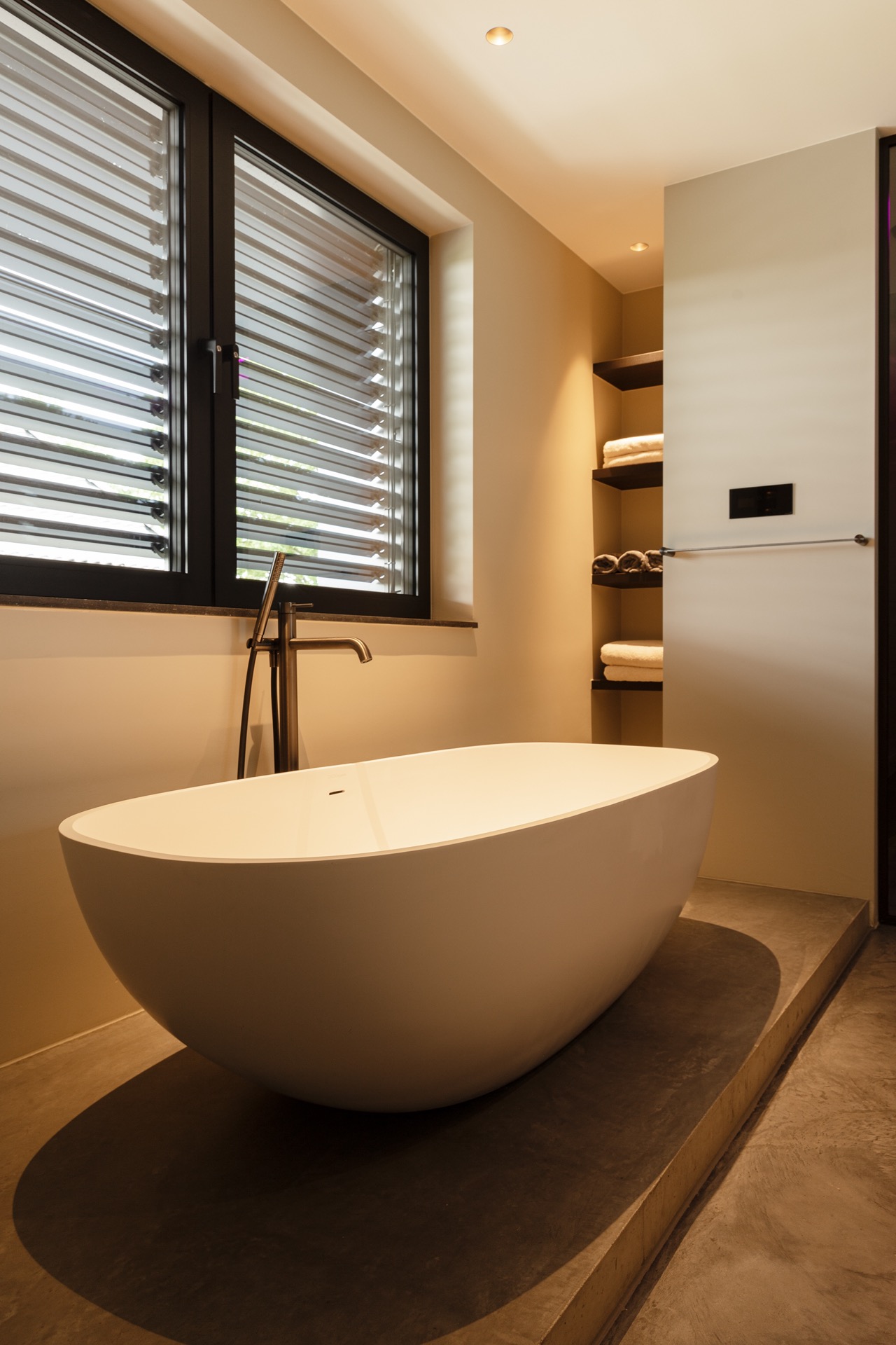 floated concrete floor in new-build villa: bathroom with freestanding bathtub, shutter window and floated concrete floor, Luxury, Design, Exclusive, Modern, Custom Made, Special, Beautiful