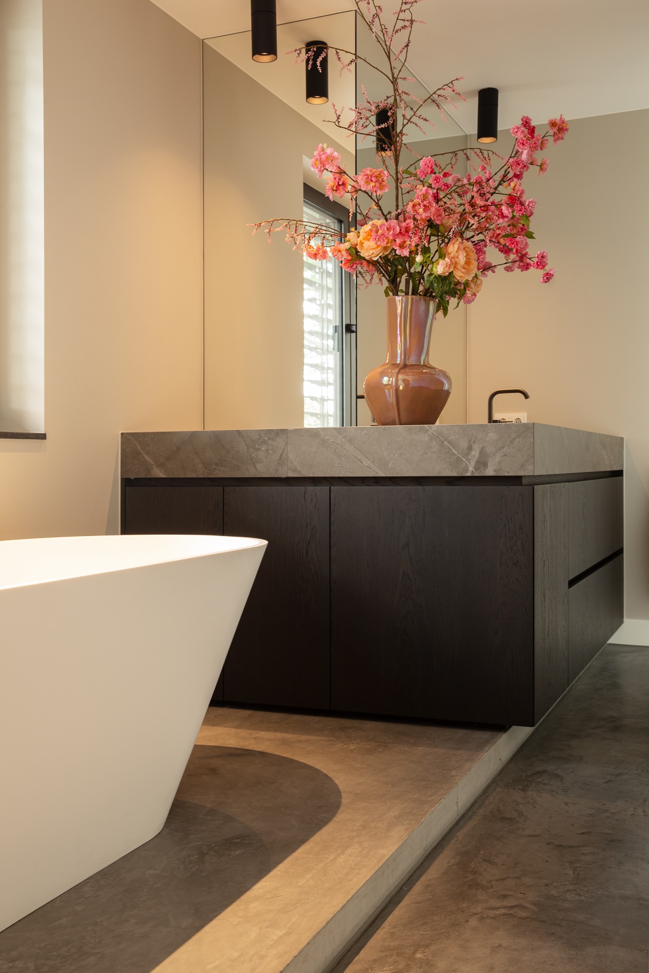 floated concrete floor in new-build villa: modern kitchen wall with natural stone fronts and dark hood; floated concrete, Luxury, Design, Exclusive, Modern, Custom Made, Special, Beautiful