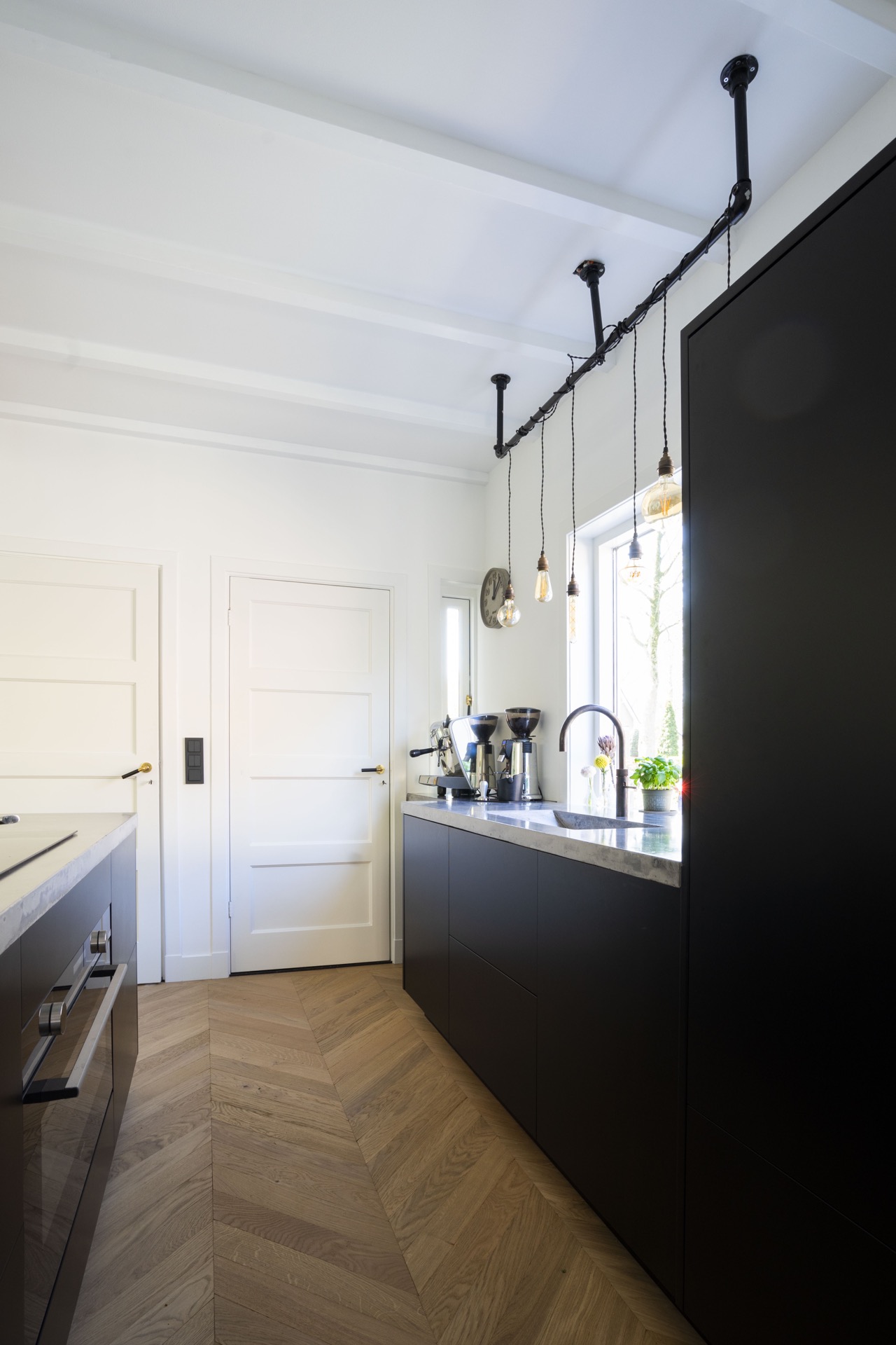 cucina su misura con isola e lavello integrato: parete cucina con piano, porte bianche e luci sospese su binario nero, Luxury, Design, Exclusive, Modern, Custom Made, Special, Beautiful