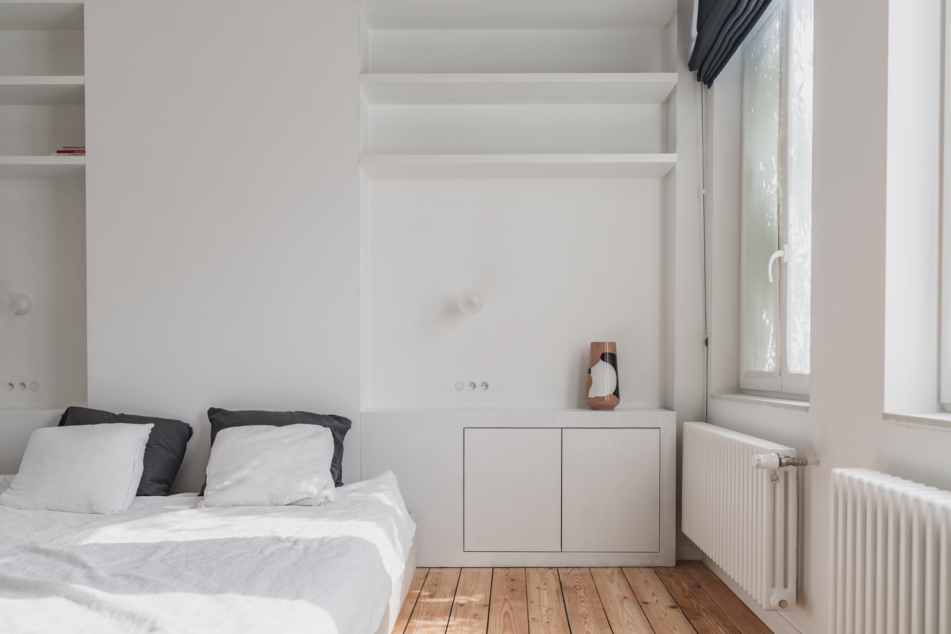 handleless walnut kitchen: bedroom with built-in niches above cabinets and a view of the radiator and window area, Luxe, Design, Exclusief, Modern, Maatwerk, Bijzondere, Mooie
