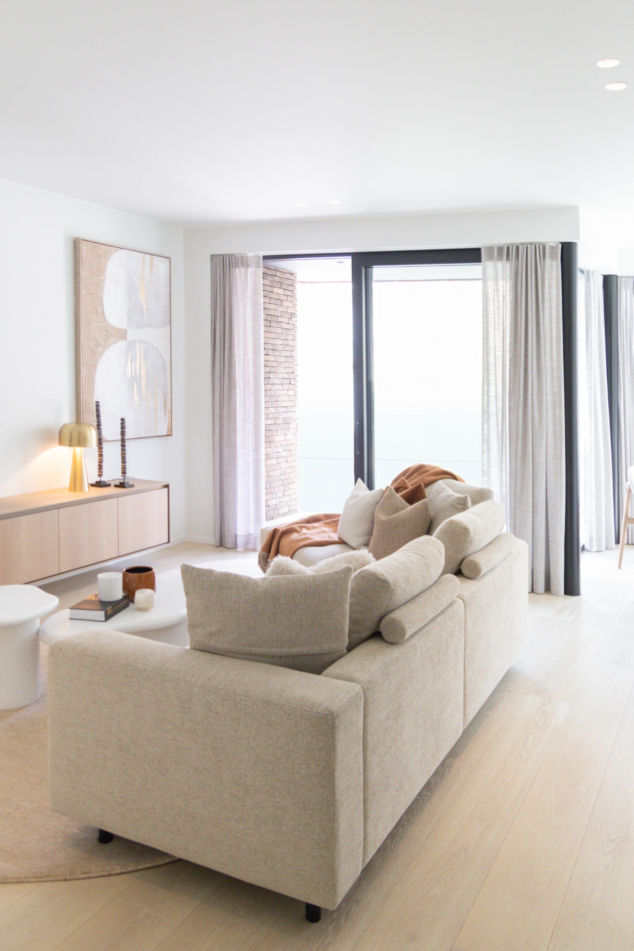 interno minimalista caldo su misura: soggiorno spazioso con divano ad angolo, tende grigie e grandi porte in vetro, Luxe, Design, Exclusief, Modern, Maatwerk, Bijzondere, Mooie