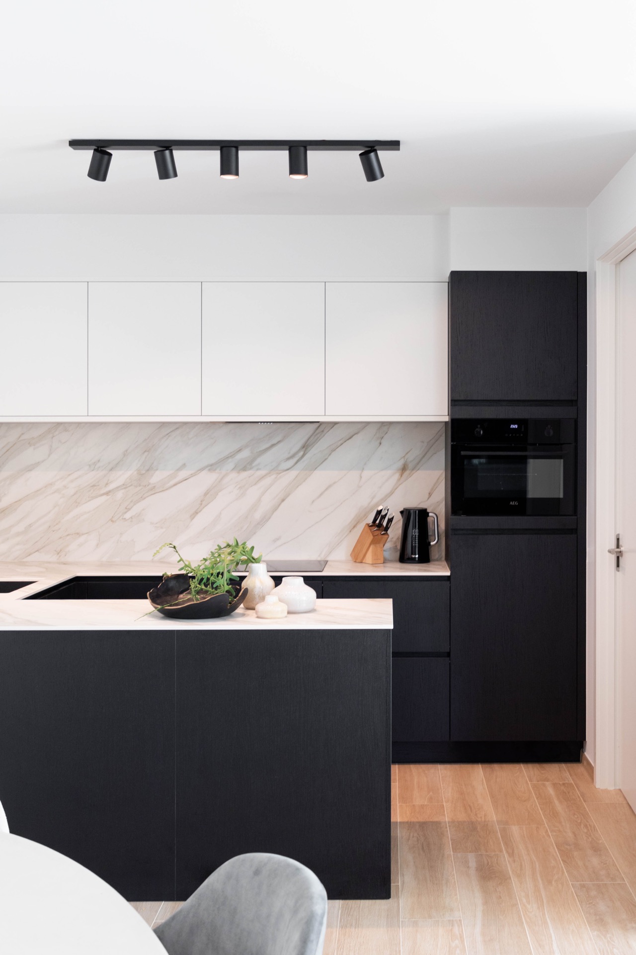 interno arioso con colori neutri: parete della cucina moderna con frontali bianchi, schienale effetto marmo e basi scure, Luxury, Design, Exclusive, Modern, Custom Made, Special, Beautiful