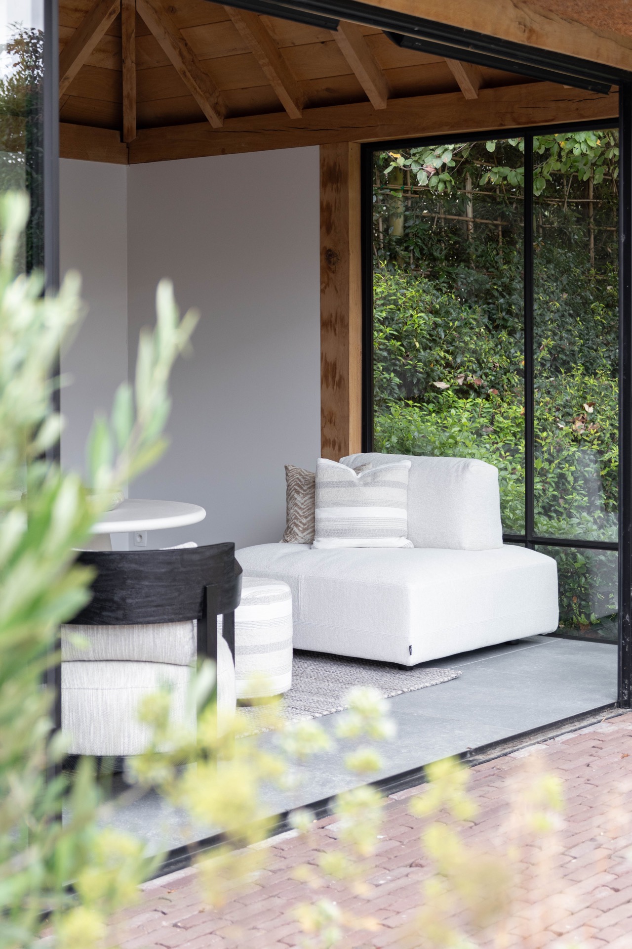 poolhouse con tetto in paglia: area lounge bianca nel poolhouse con telai neri e vista sul giardino, Luxury, Design, Exclusive, Modern, Custom Made, Special, Beautiful