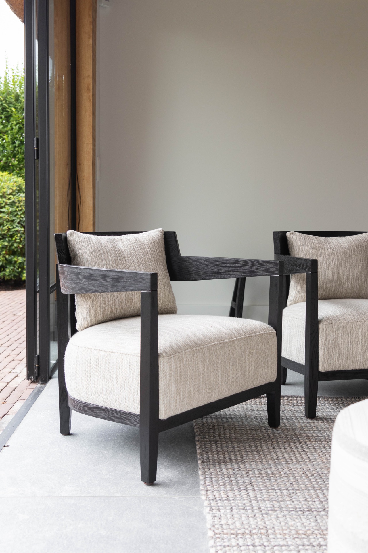 poolhouse con tetto in paglia: poltrona lounge vicino a una finestra aperta nel poolhouse con vista sul giardino, Luxury, Design, Exclusive, Modern, Custom Made, Special, Beautiful