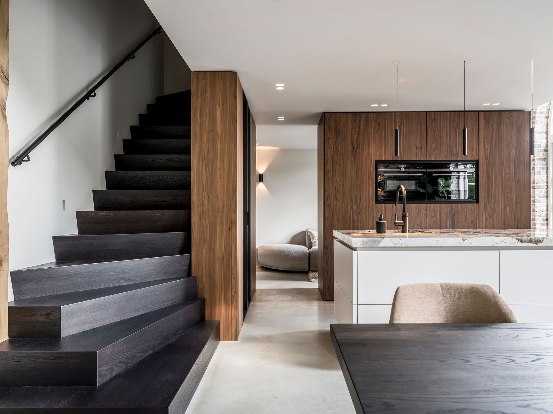 custom walnut kitchen with natural stone countertop: staircase and kitchen with custom walnut fronts and pendant lighting, Luxe, Design, Exclusief, Modern, Maatwerk, Bijzondere, Mooie