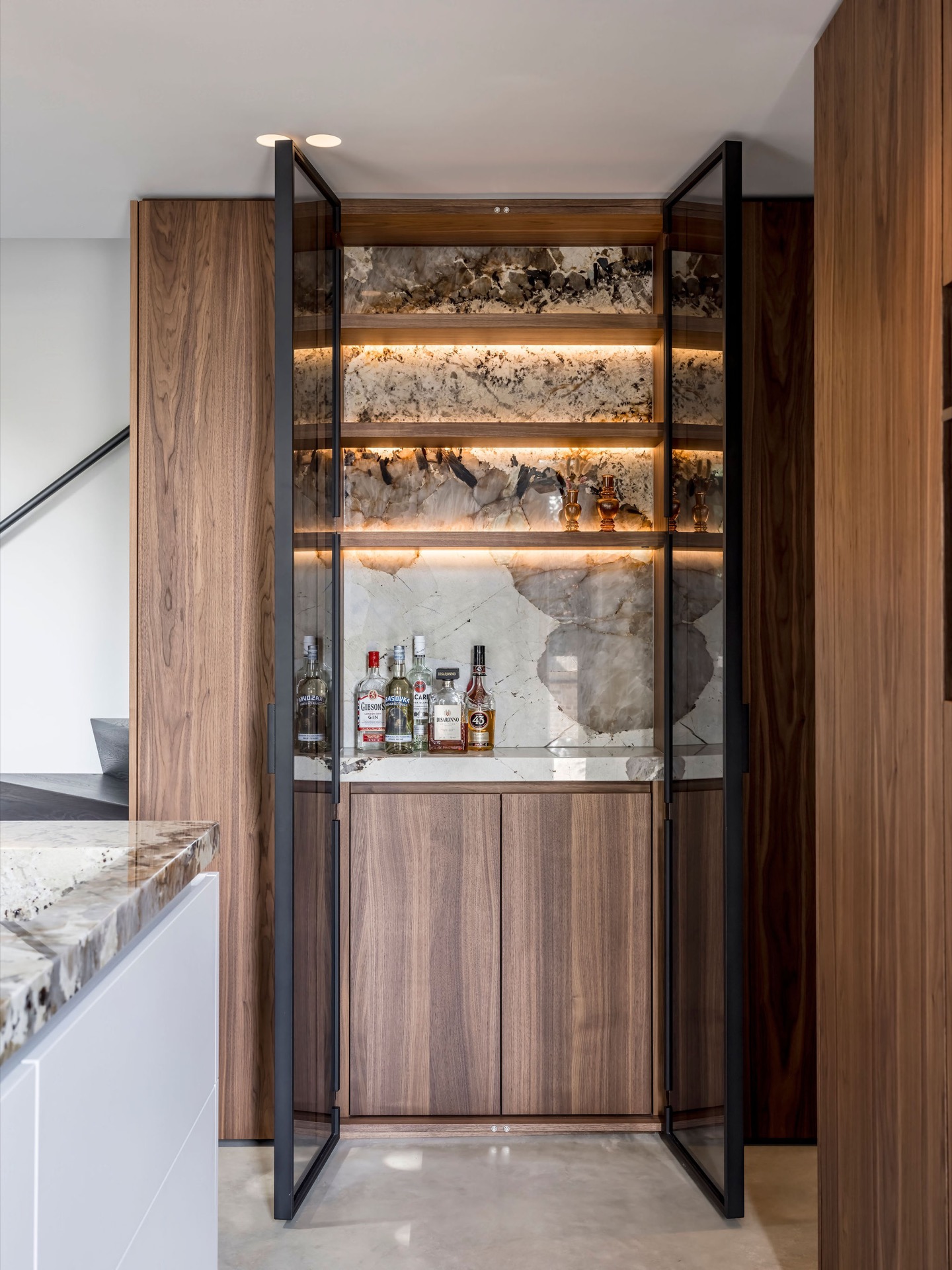 custom walnut kitchen with natural stone countertop: living area with walnut wall panels and view toward a brick arch opening, Luxe, Design, Exclusief, Modern, Maatwerk, Bijzondere, Mooie