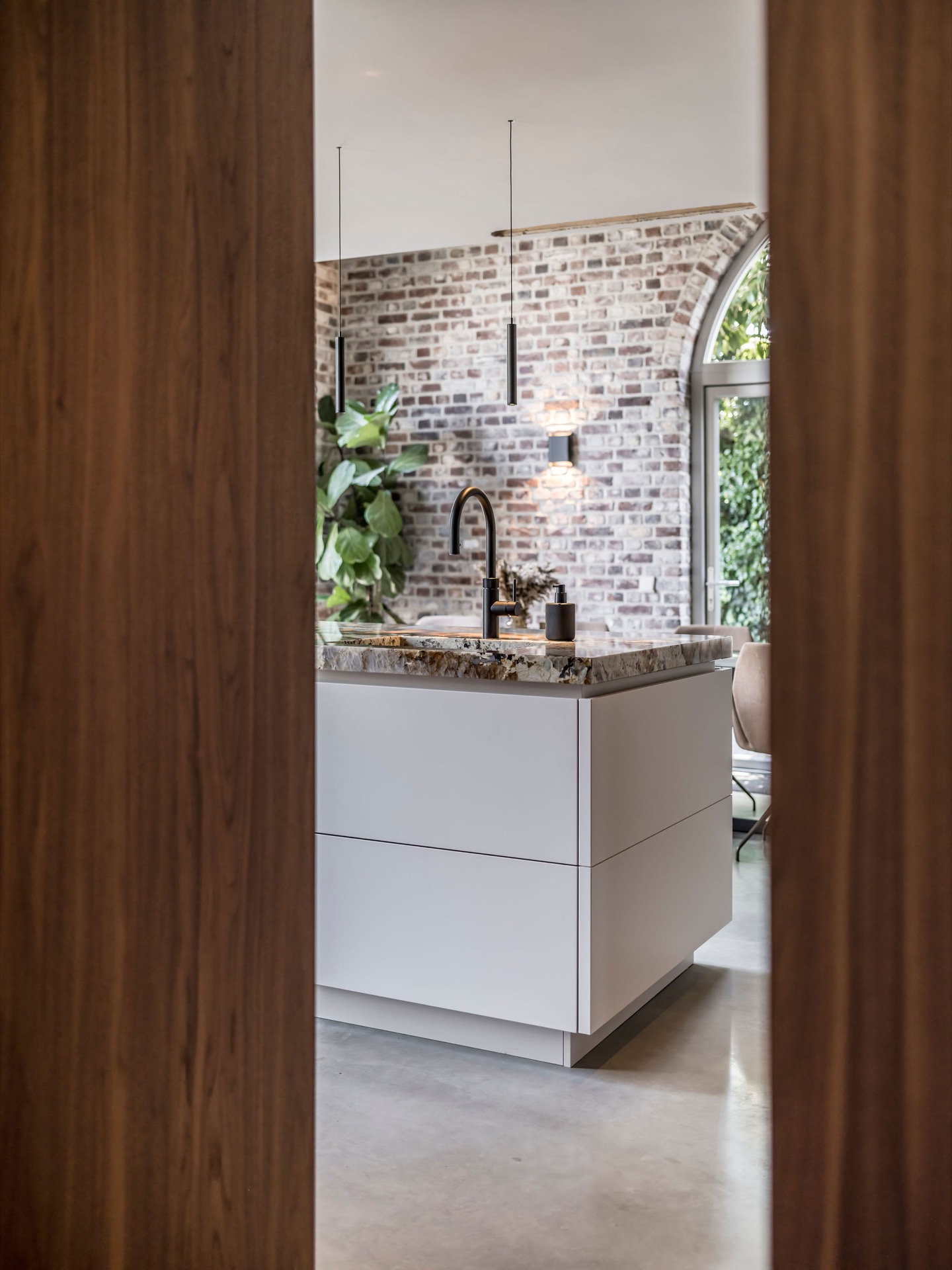 custom walnut kitchen with natural stone countertop: passage with walnut walls and a view to the kitchen with a brick arch, Luxe, Design, Exclusief, Modern, Maatwerk, Bijzondere, Mooie