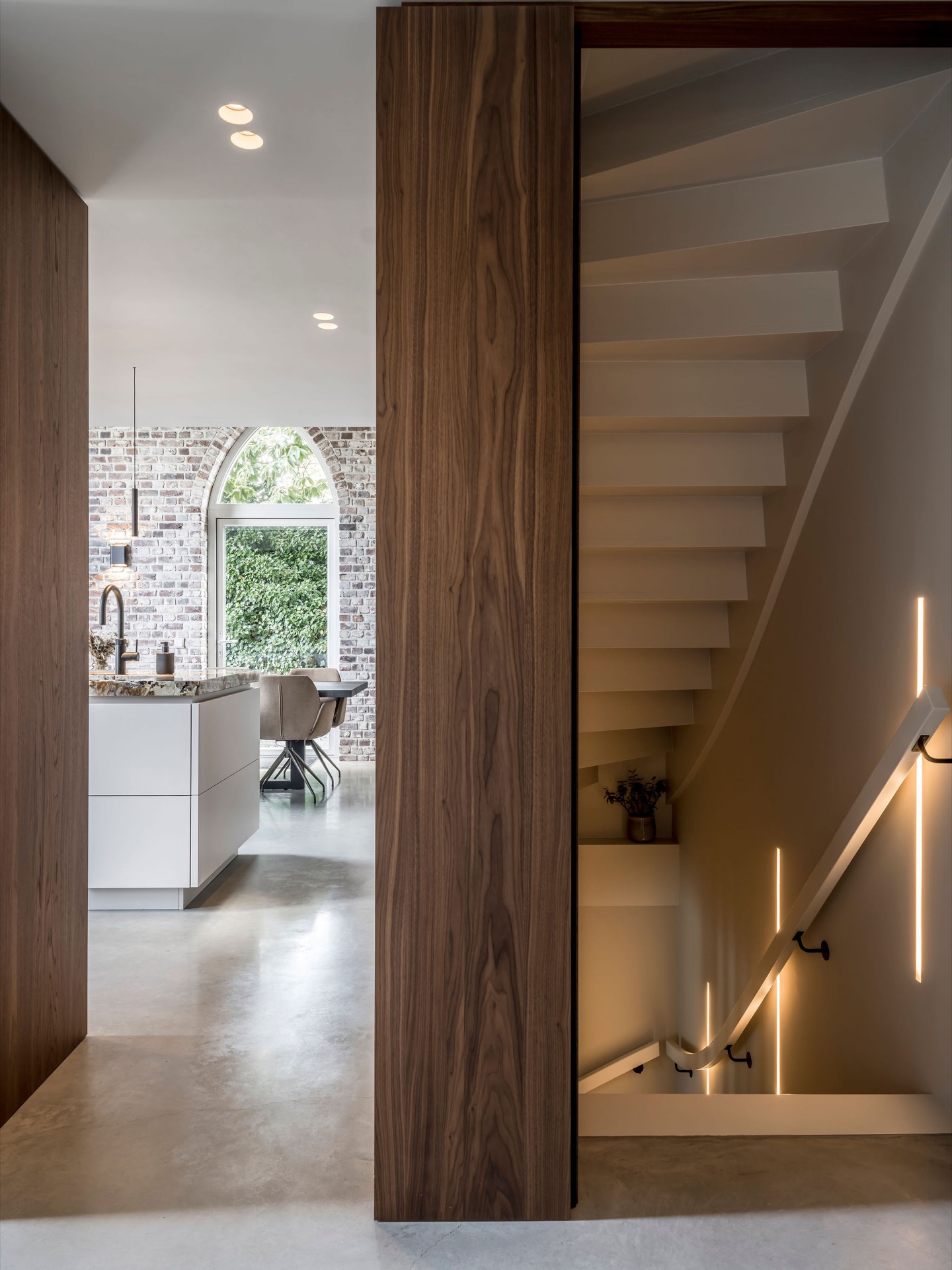 custom walnut kitchen with natural stone countertop: staircase in a hallway with a walnut column, dark treads and handrail, Luxe, Design, Exclusief, Modern, Maatwerk, Bijzondere, Mooie