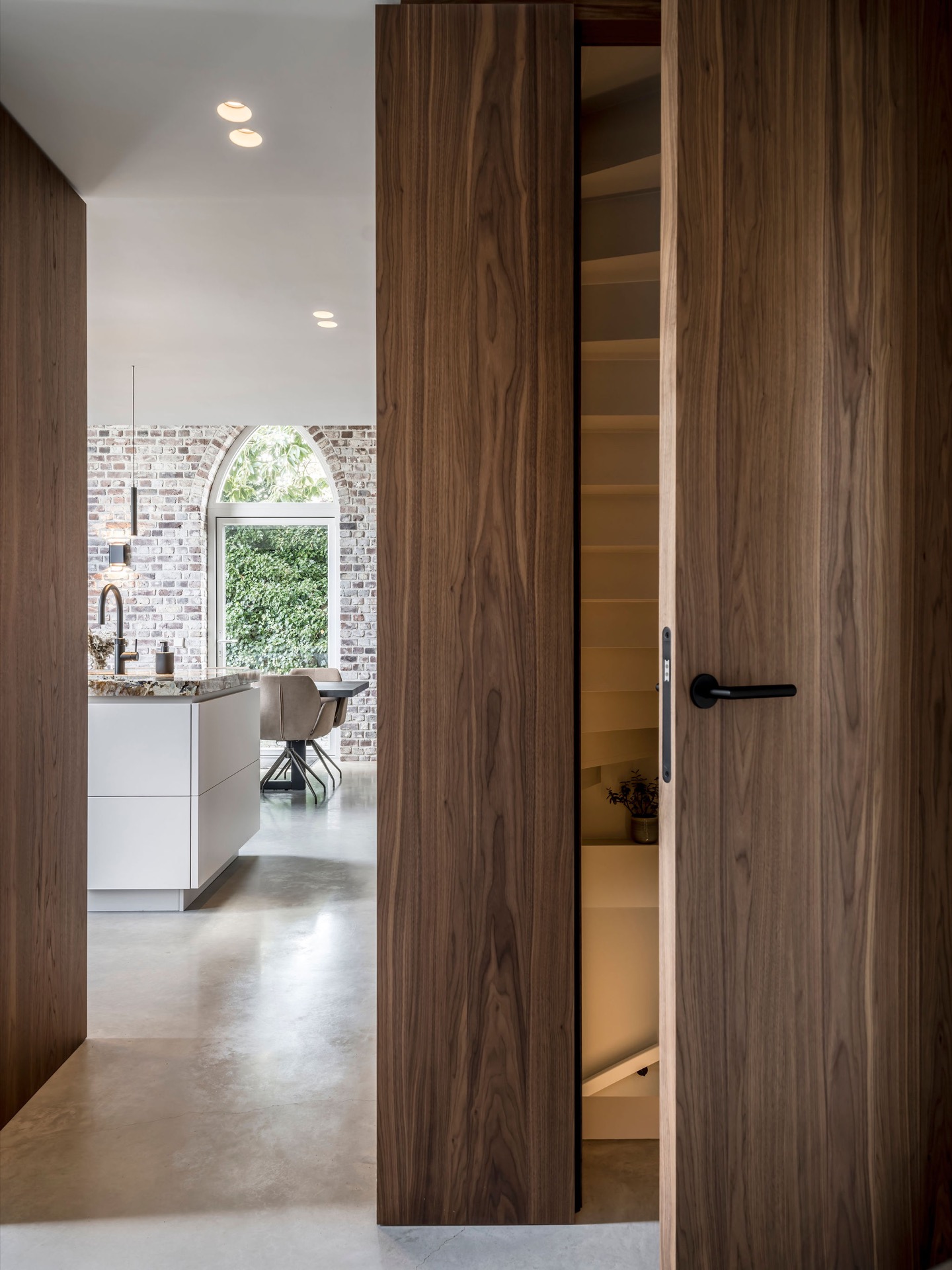 custom walnut kitchen with natural stone countertop: side view of kitchen with walnut walls, glass niche and staircase in, Luxe, Design, Exclusief, Modern, Maatwerk, Bijzondere, Mooie