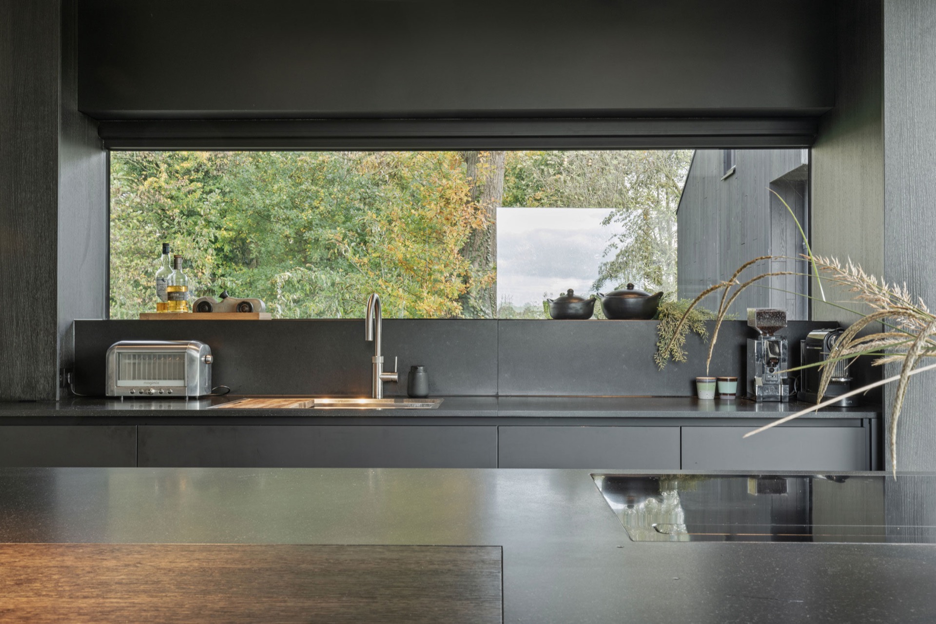 indoor-outdoor kitchen: kitchen countertop with dark fronts and large window framed by the kitchen wall, Luxe, Design, Exclusief, Modern, Maatwerk, Bijzondere, Mooie